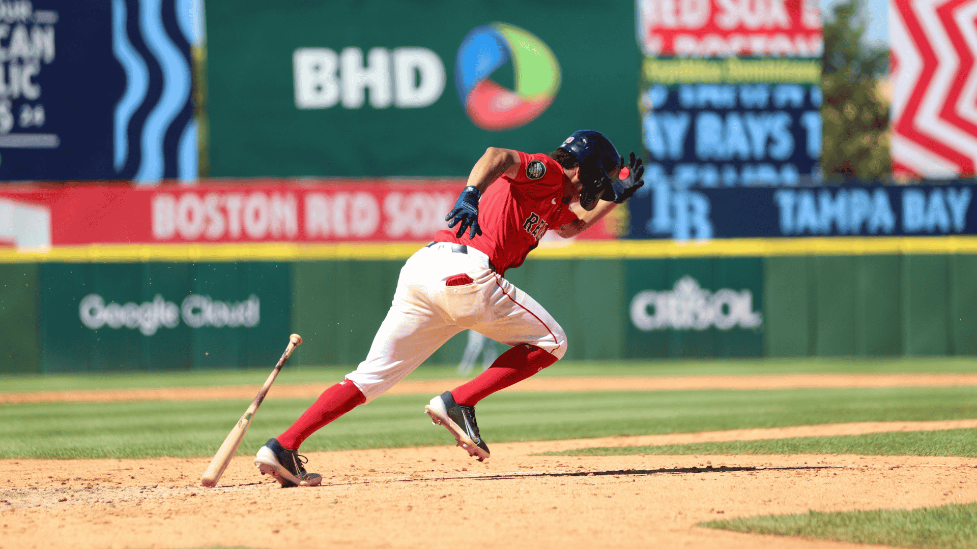 a baseball player drops his bat and sprints from home plate after hitting the ball