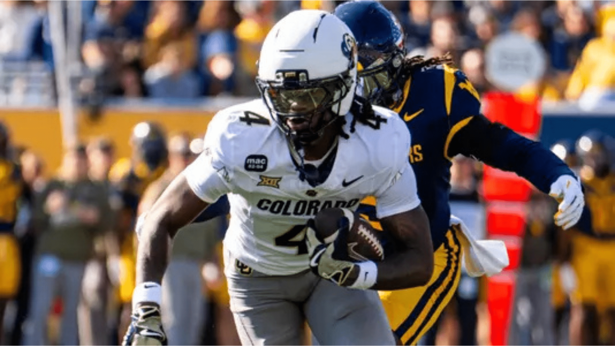 a colorado football player wearing number 4 runs with the ball while a defender in blue and yellow pursues him on the field