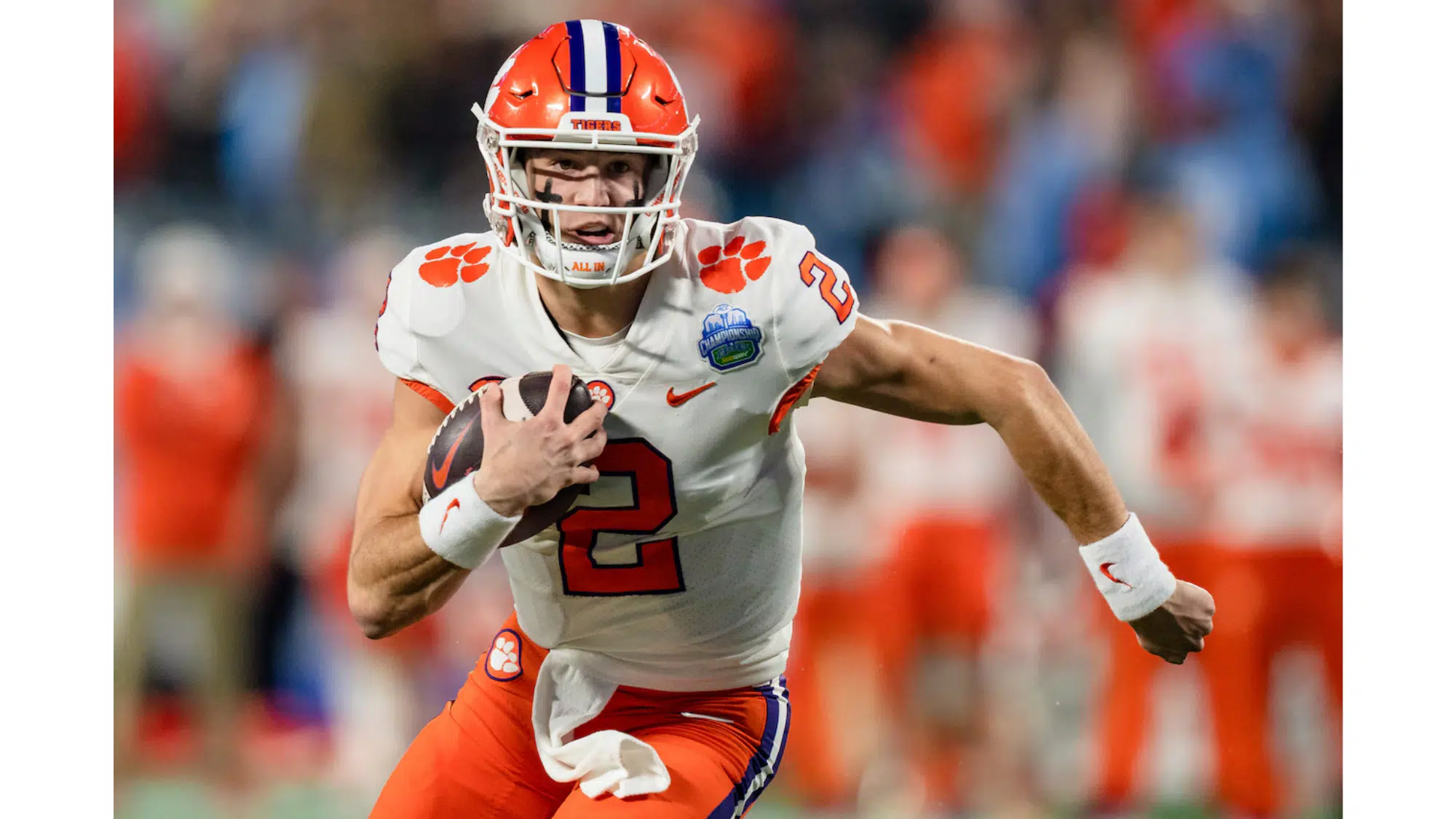a nil earner football player wearing number 2 prepares to throw a pass during a game with teammates in the background
