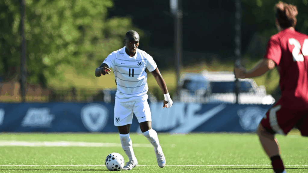 a soccer player in a white uniform demonstrating how to shoot a soccer ball during a match on a sunny field