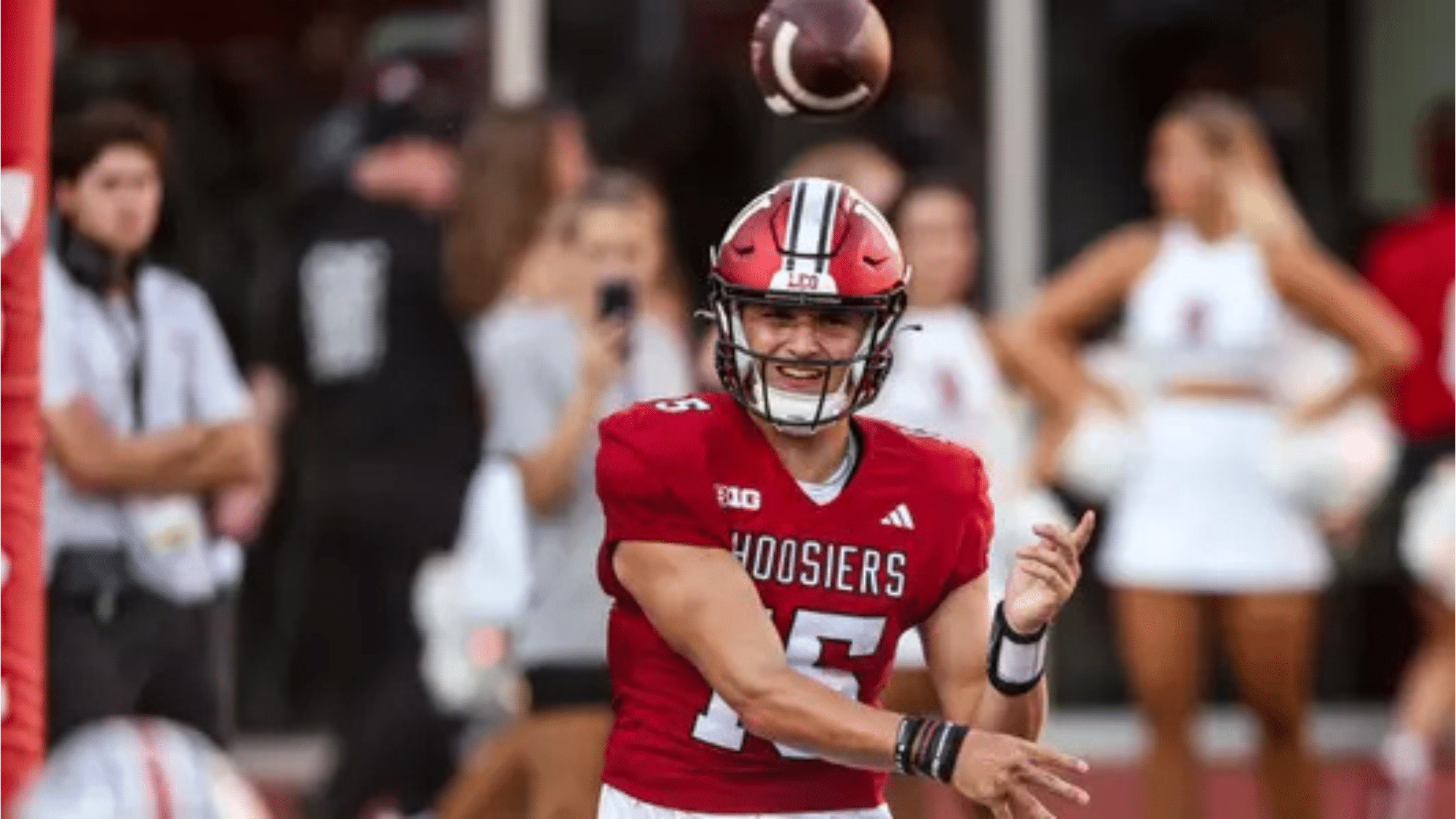 an indiana hoosiers football top nil earners player wearing number 5 throws a pass during a game while teammates and fans watch in the background
