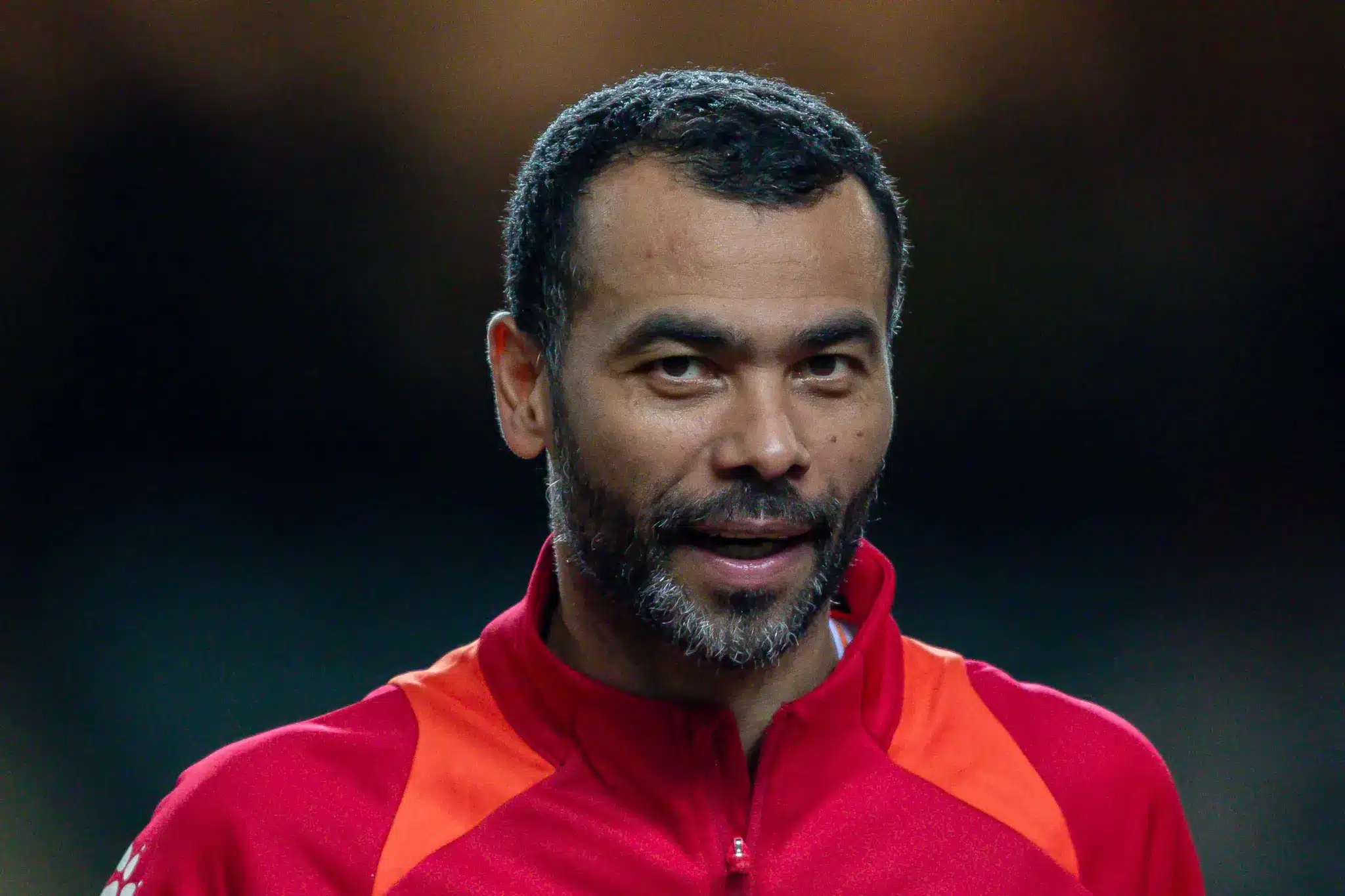 ashley cole in a red training top looking ahead on the field