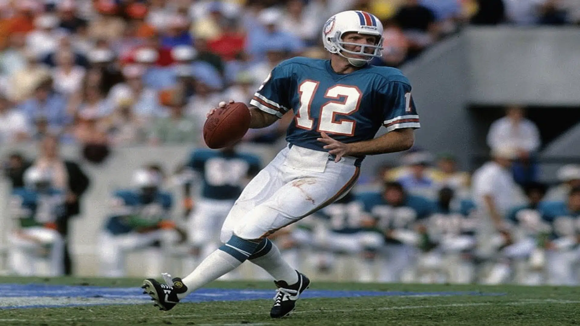 bob griese quarterback rolls out with the ball during a game