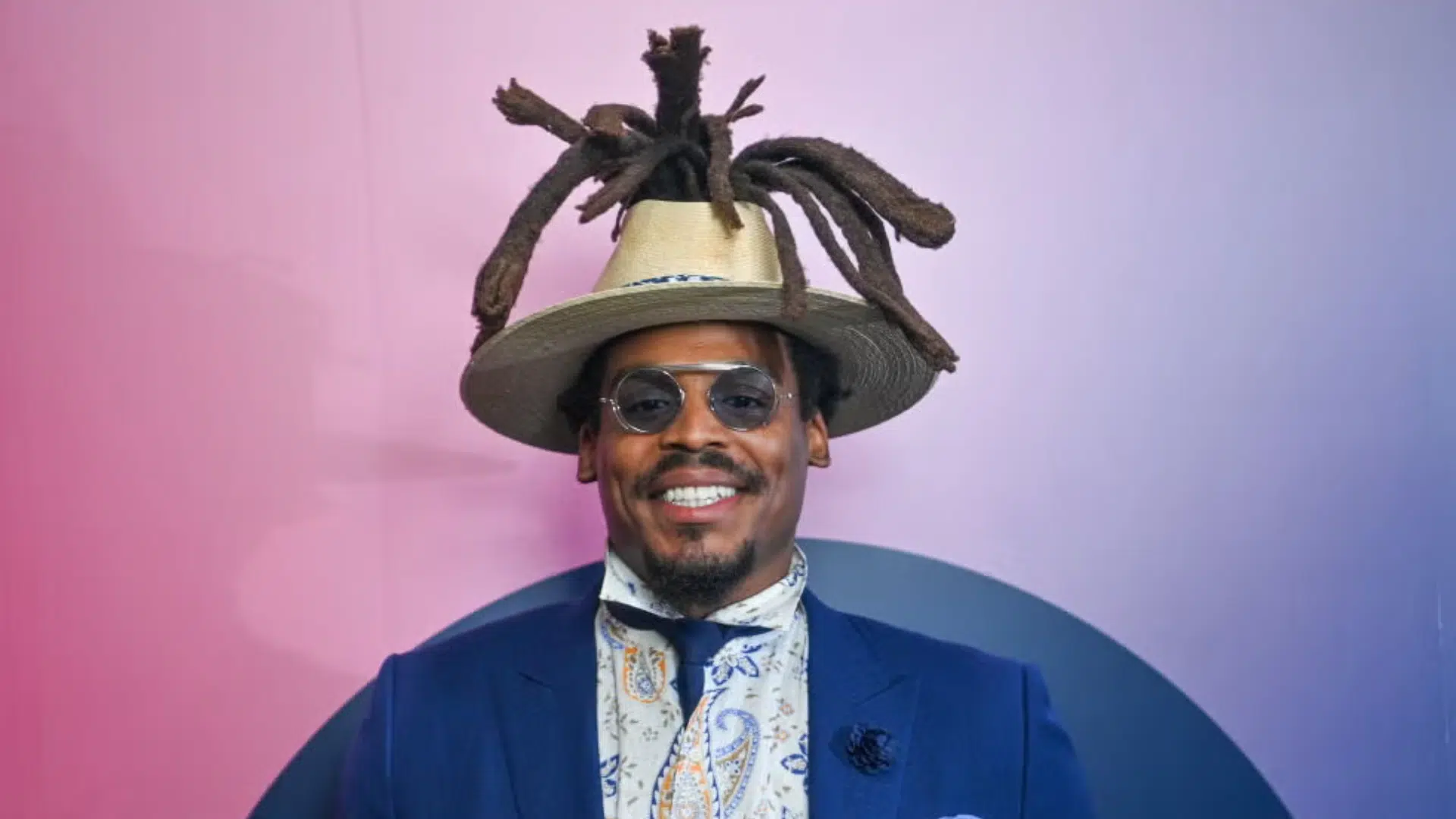 cam newton stylish man smiles while wearing a suit hat and sunglasses