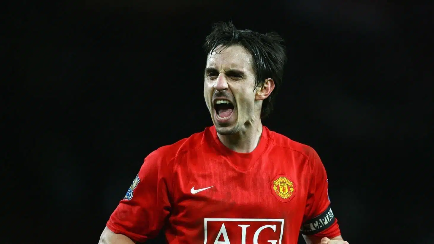 gary neville in a red manchester united jersey shouting during a match