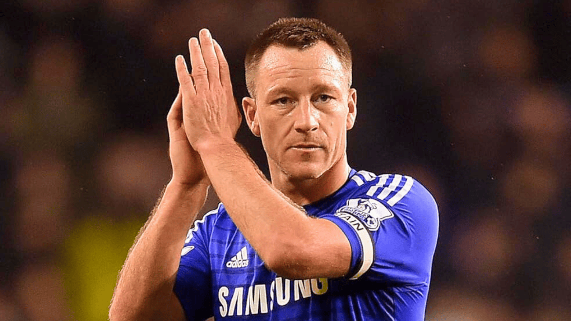 john terry in a blue chelsea jersey clapping on the field