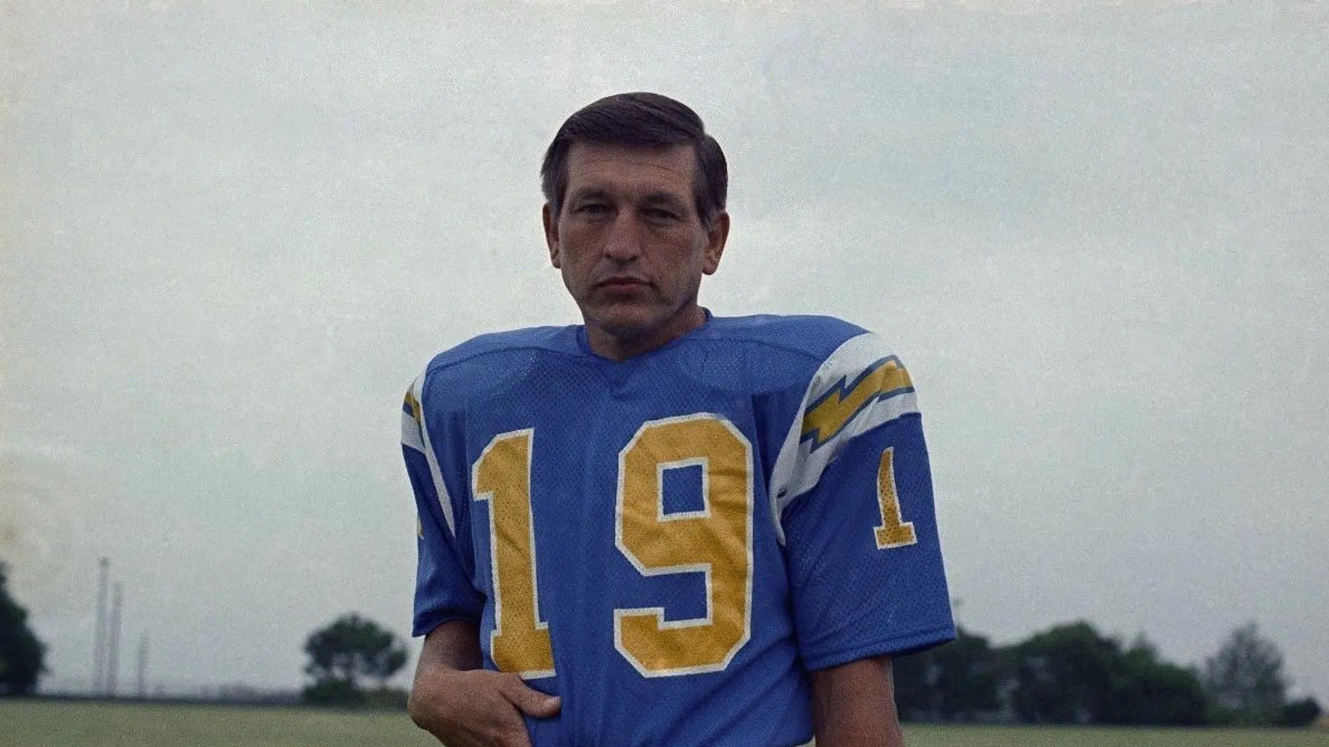 johny unitas in a blue and yellow jersey standing in a field