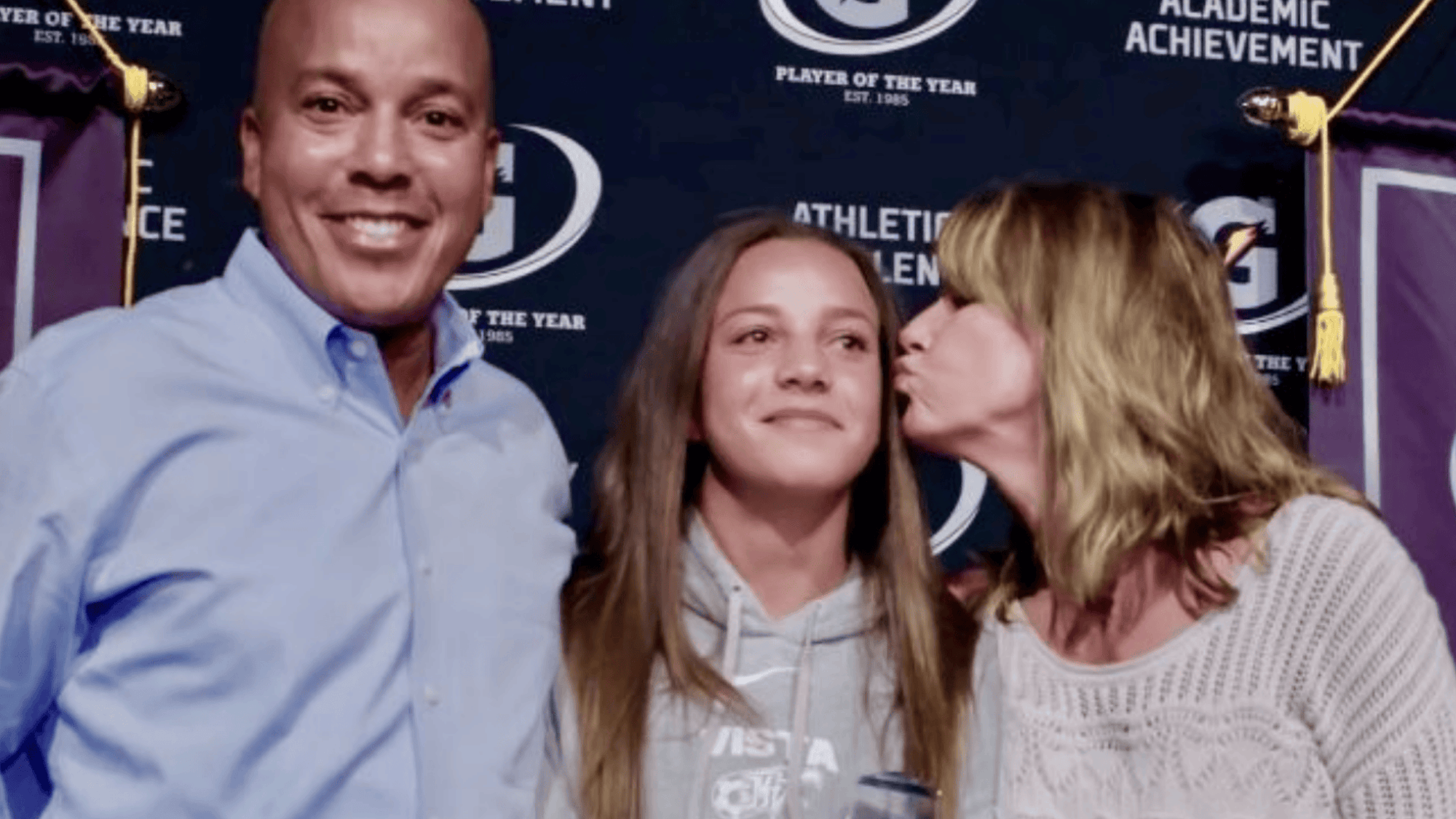 mallory swanson standing with her parents karen and horace pugh at an awards event