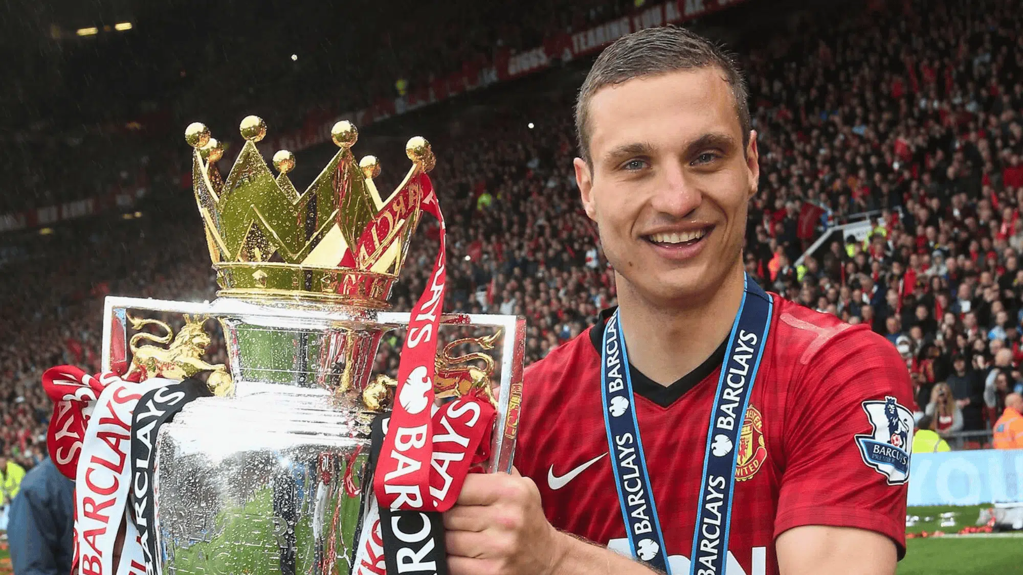 nemanja vidic holding the premier league trophy in a red manchester united jersey