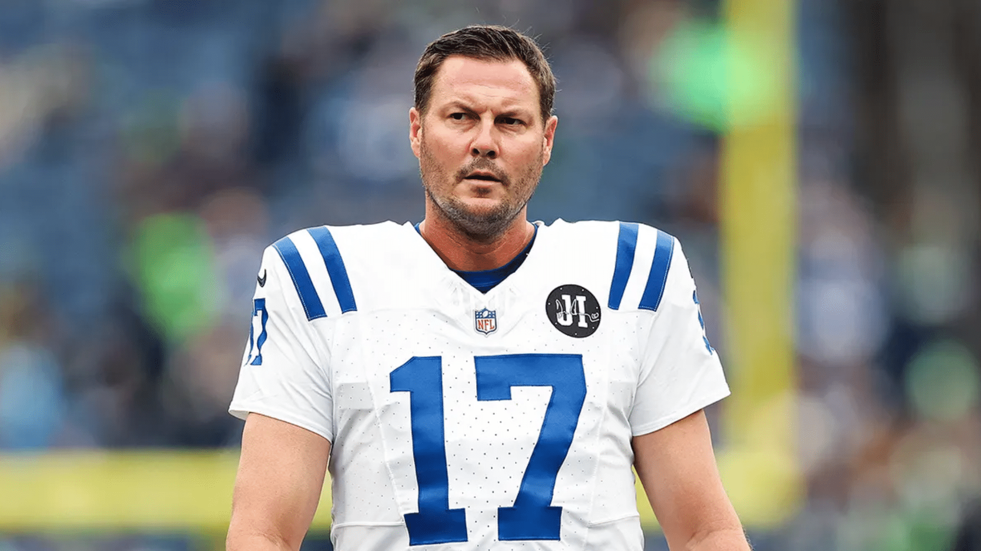 philip rivers football player in a blue jersey looks on under bright stadium lights after a game