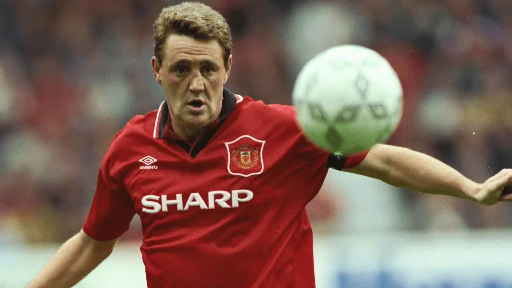 steve bruce in a red manchester united jersey controlling the ball