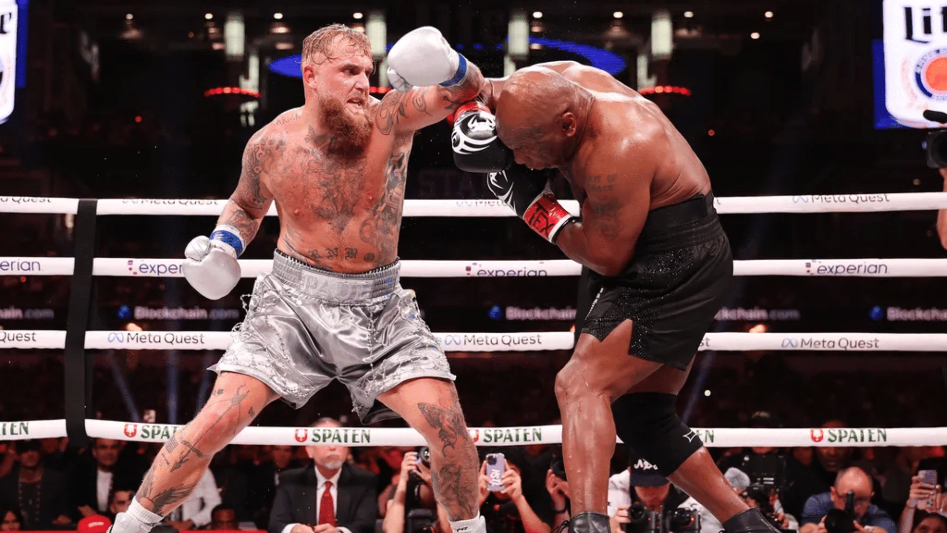 two boxers trading punches in the ring as one throws a left hook during intense boxing terms action