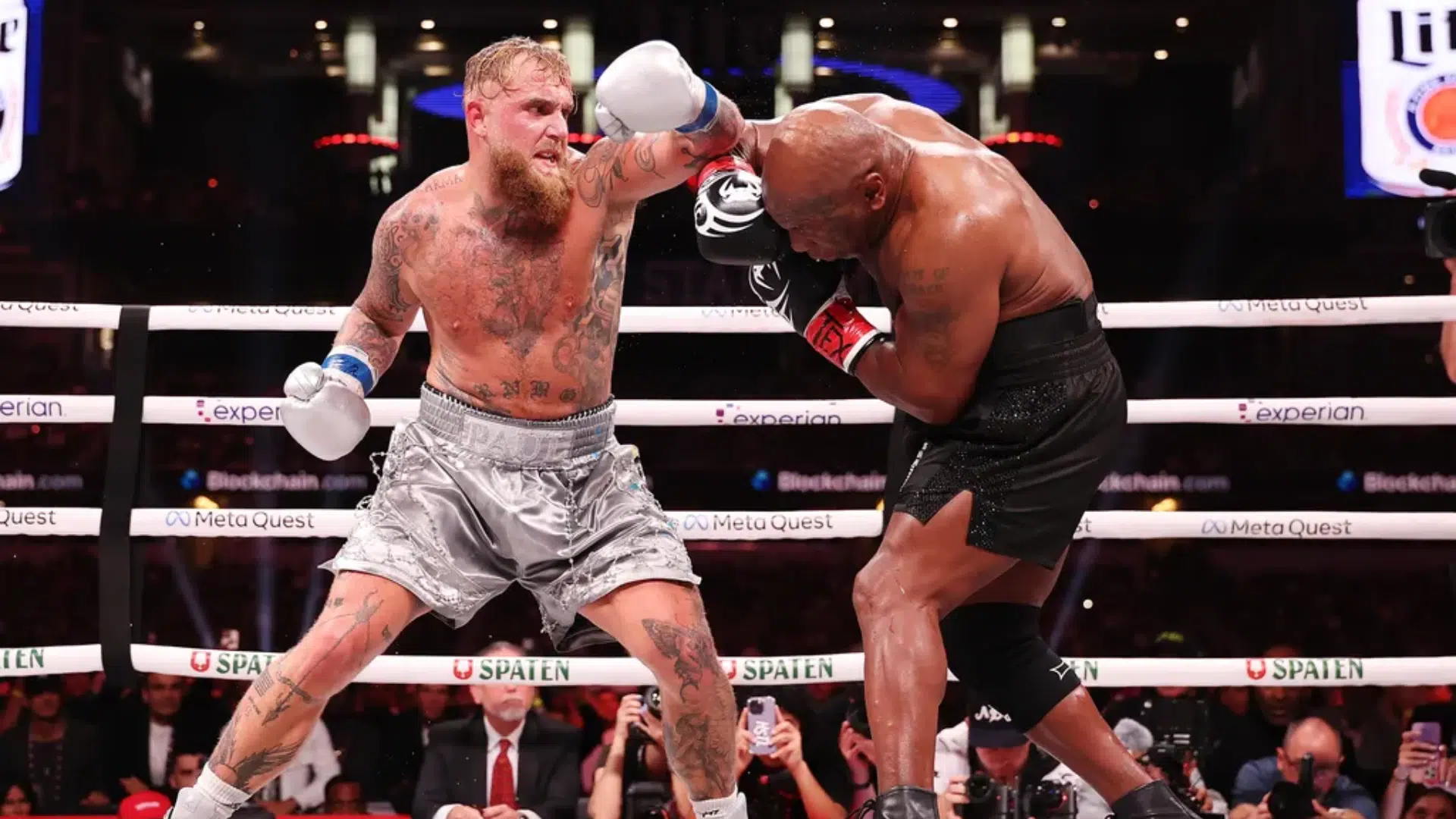 two boxers trading punches in the ring as one throws a left hook during intense boxing terms action