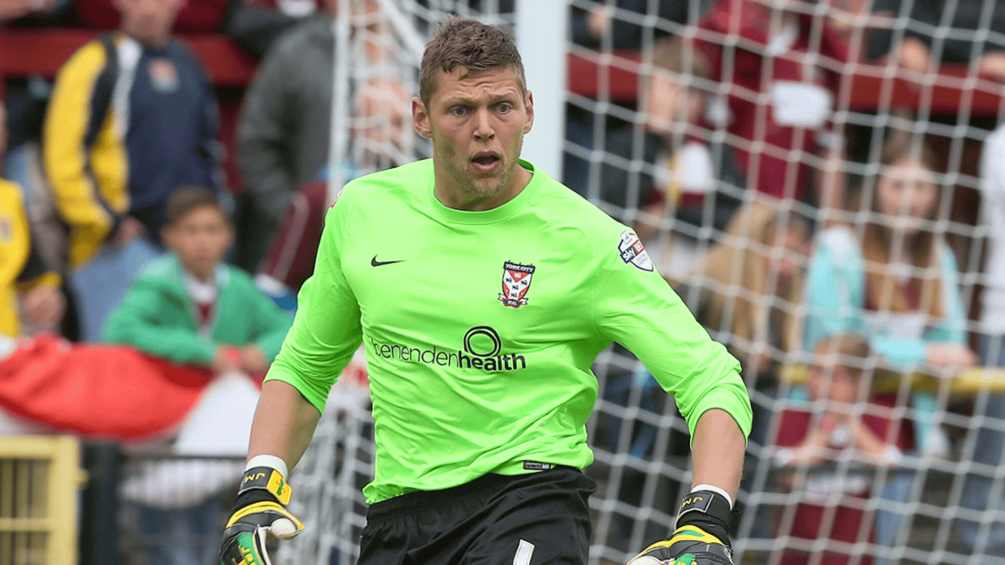This image shows jason mooney in a green kit likely playing for York City based on the team logo on the chest