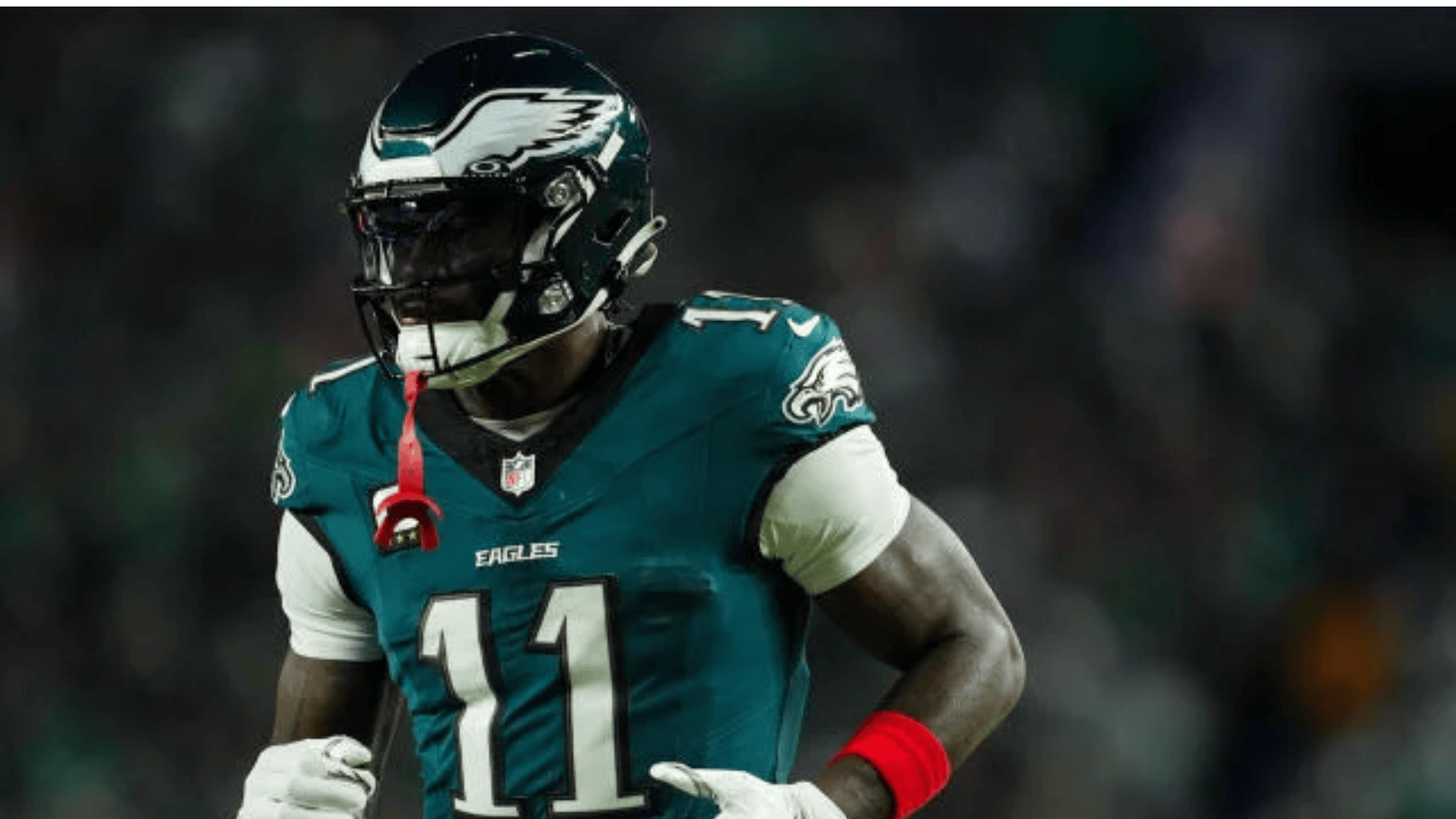 aj brown in a green eagles uniform and helmet wearing number 11 runs on the field