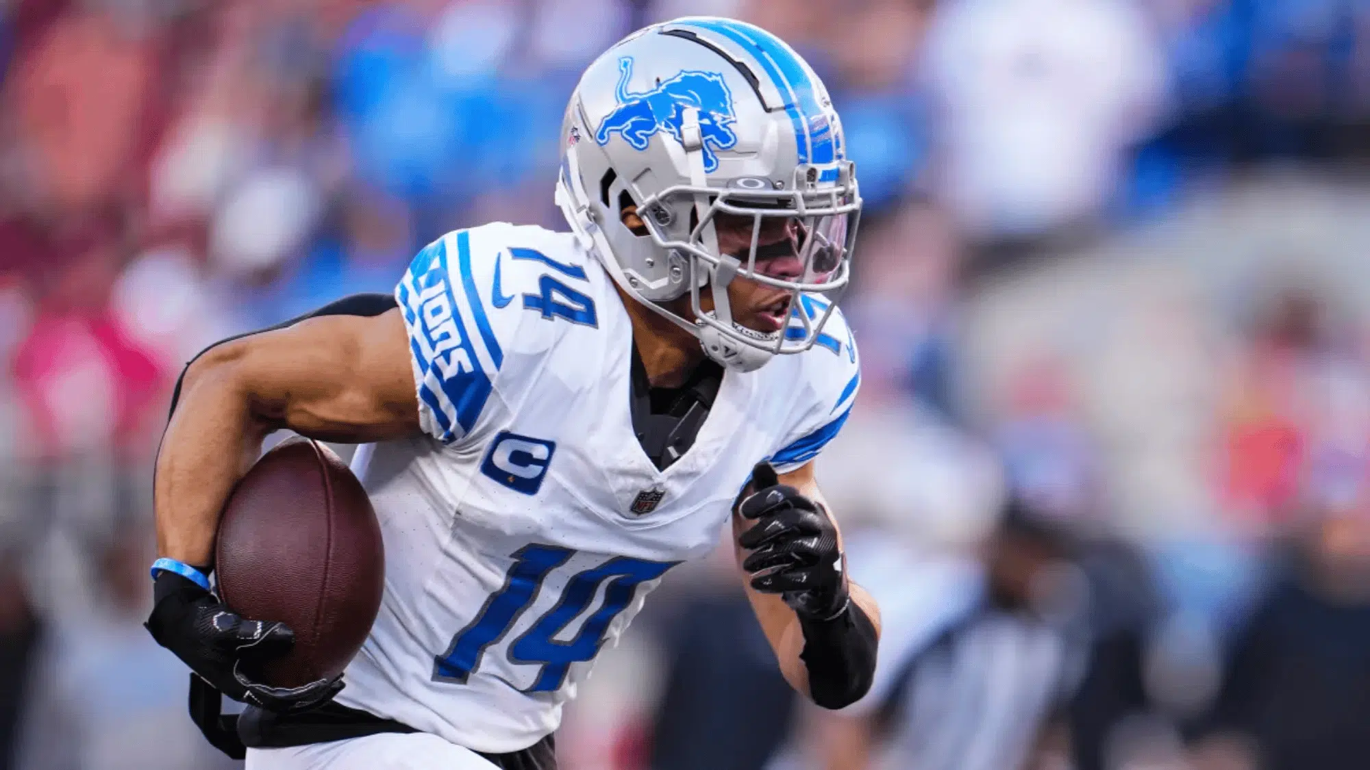 amon ra st brown in a white and blue lions uniform runs with the ball during a game