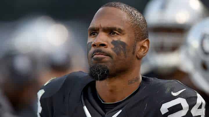 charles woodson in a black uniform with number 24 is focused and determined, with black eye paint under his eyes