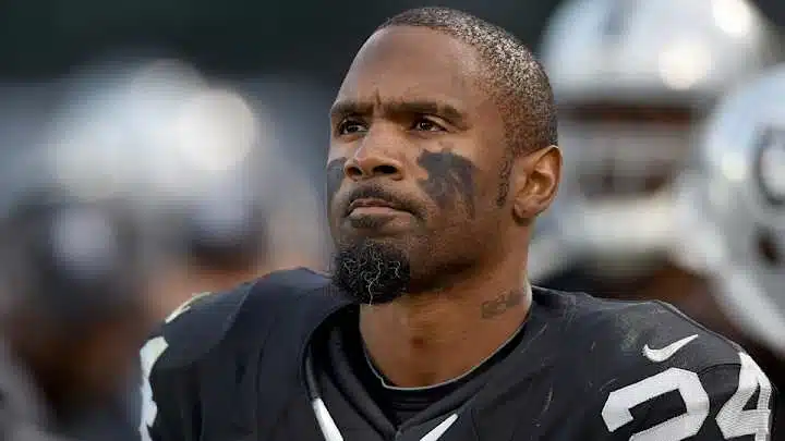 charles woodson in a black uniform with number 24 is focused and determined, with black eye paint under his eyes