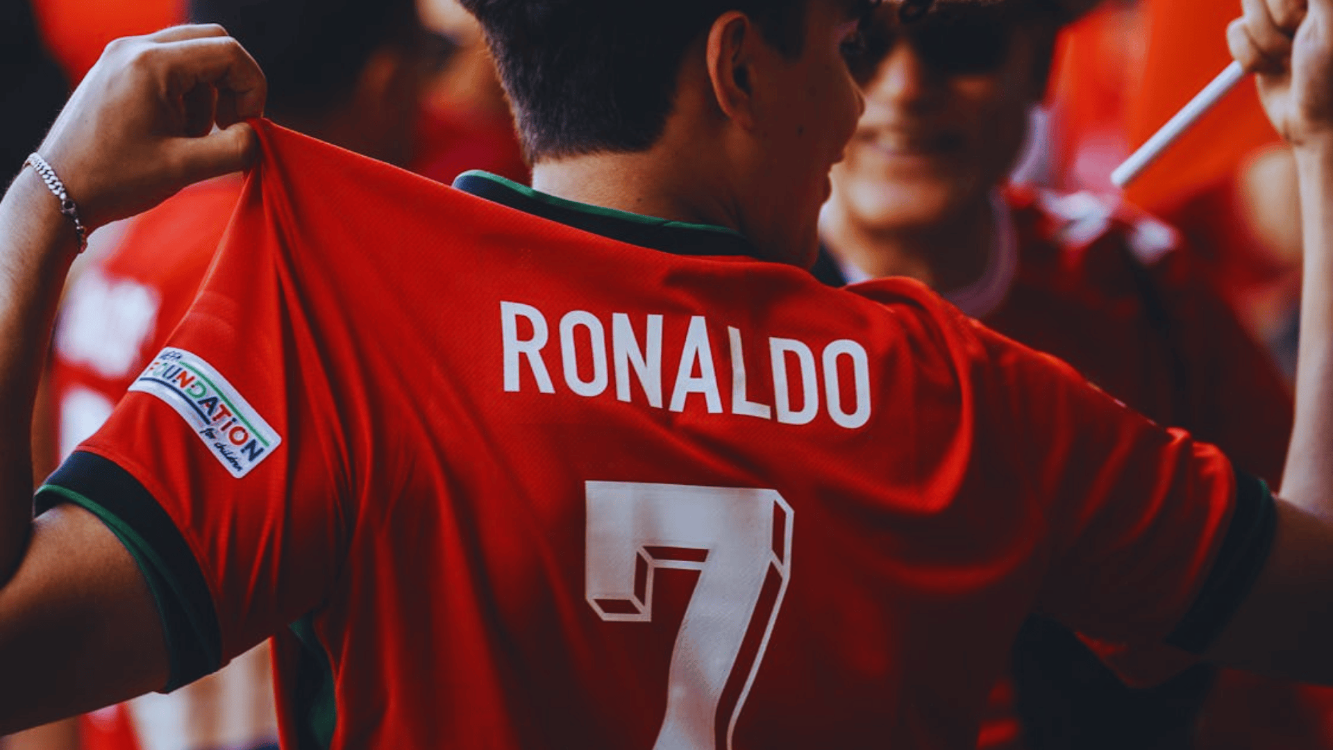 fan holding ronaldo number 7 portugal jersey at football match