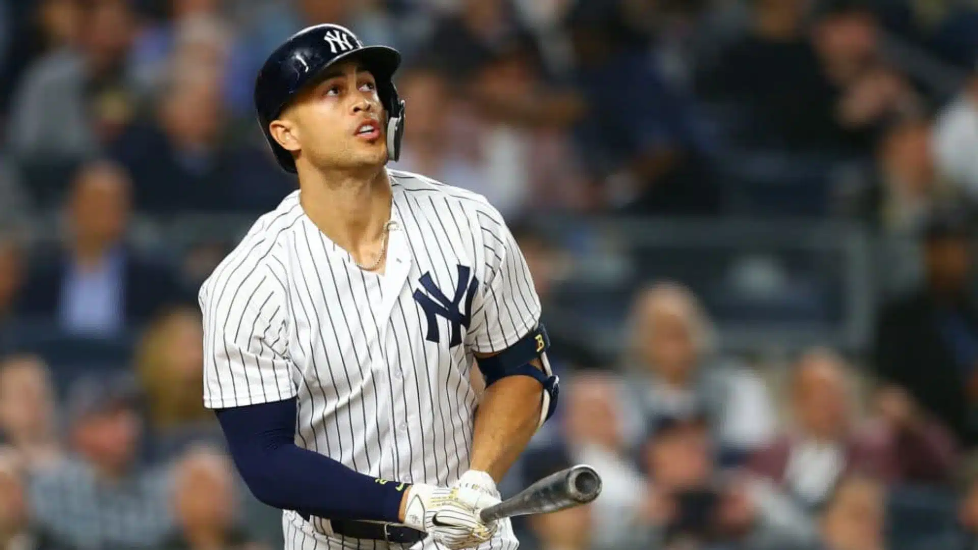 giancarlo stanton one of the oldest active mlb players watching hit ball in yankees uniform holding bat