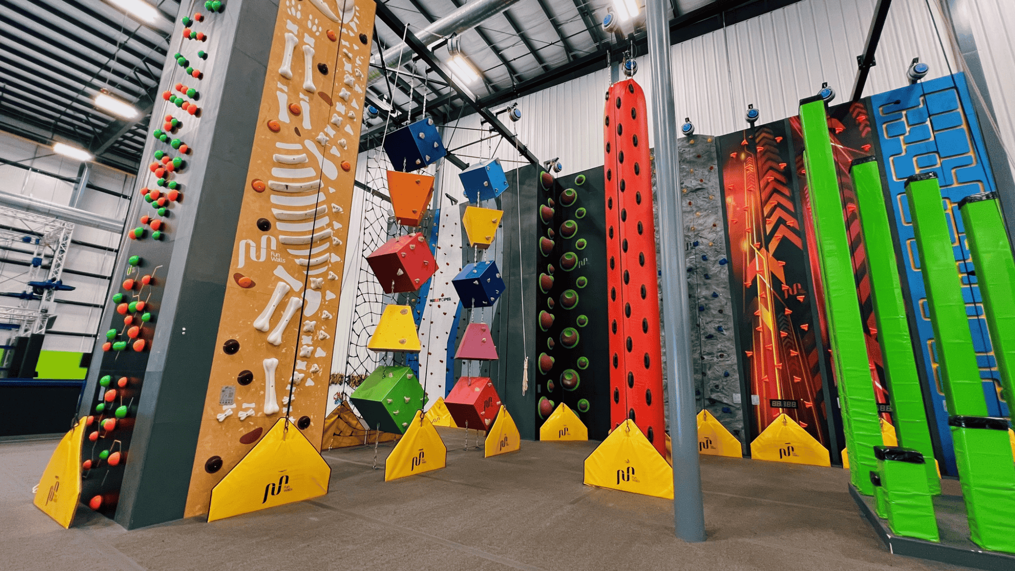 indoor climbing facility with vibrant geometric climbing walls in various colors including red yellow and green