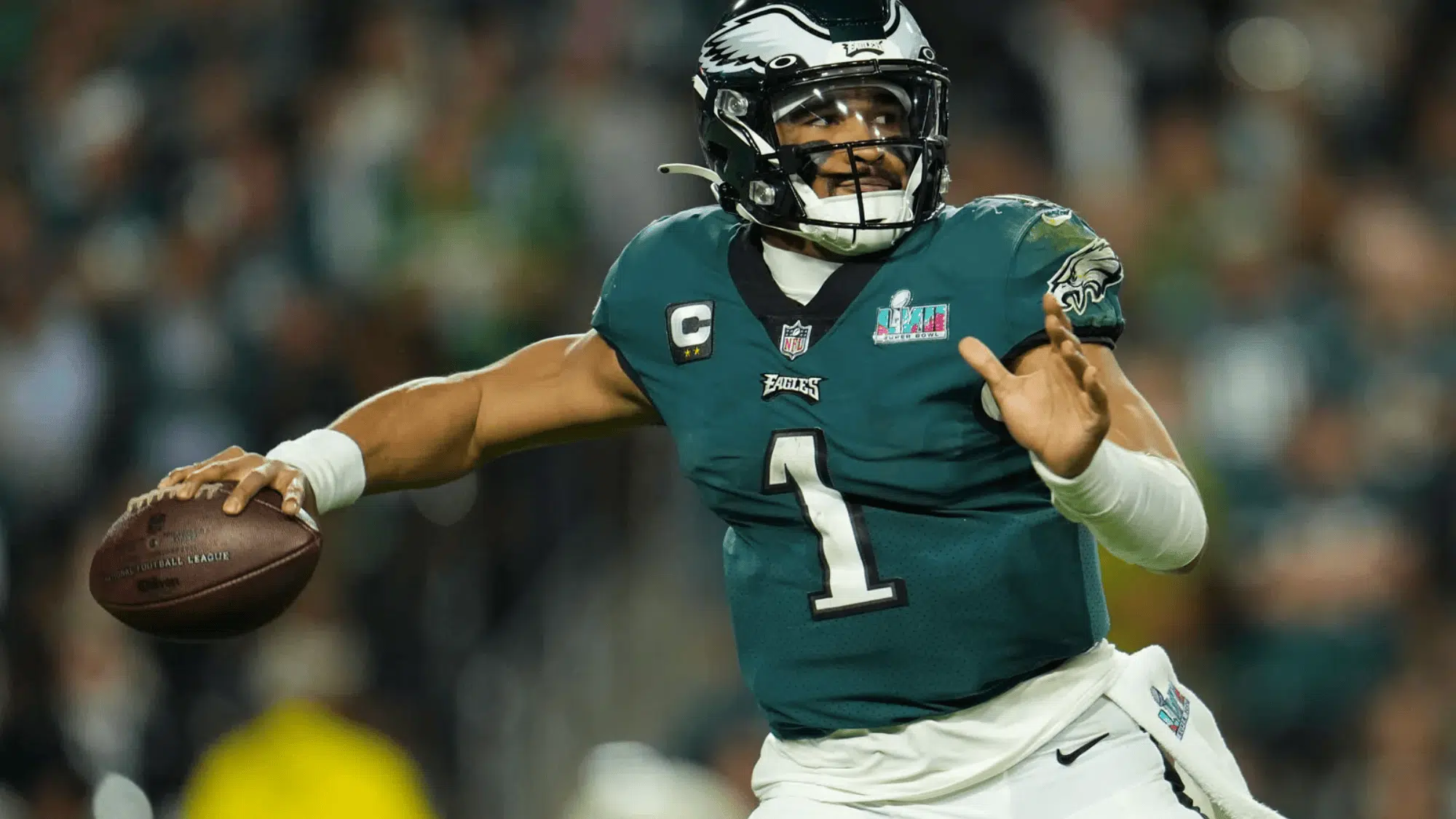 jalen hurts in green jersey poised mid throw during a game, focused
