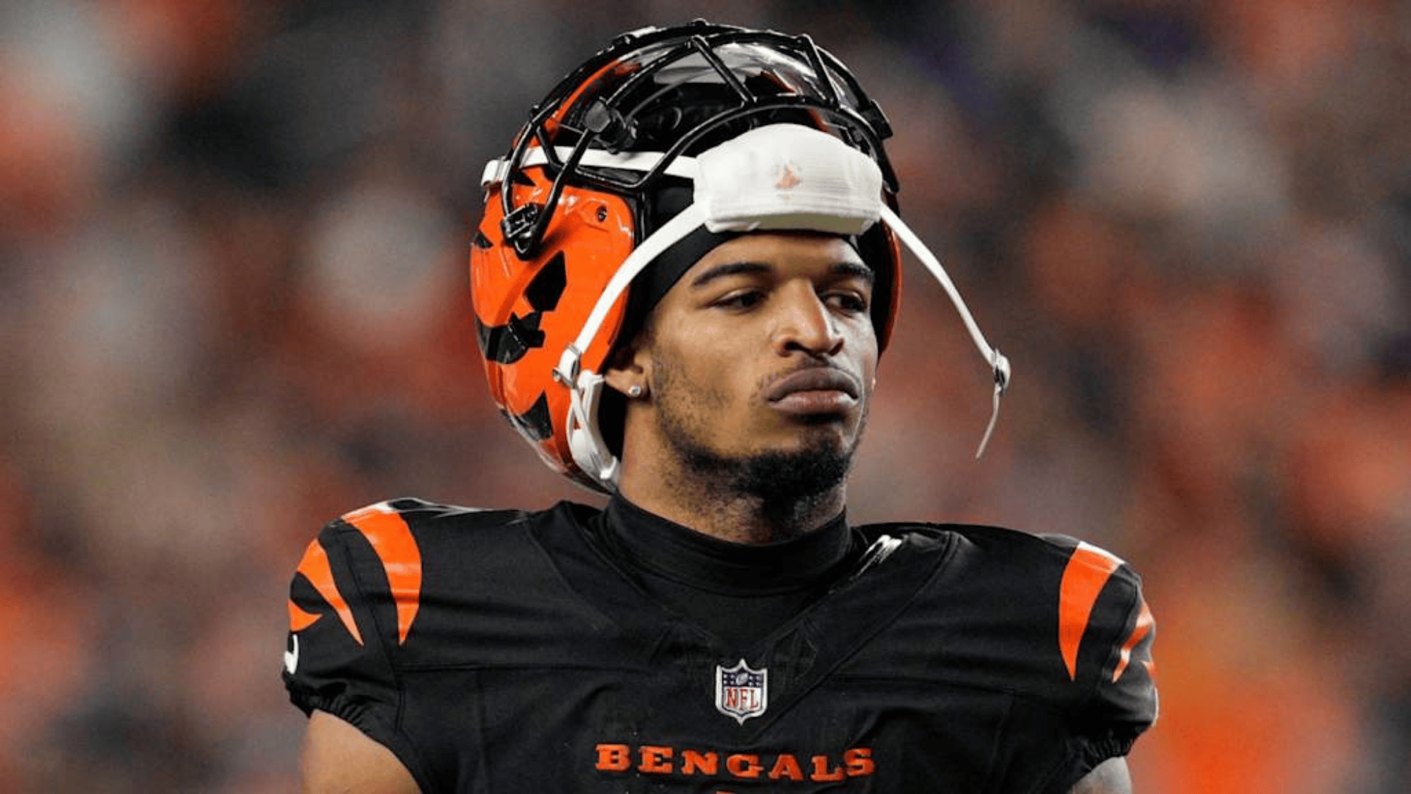ja’marr chase in a bengals uniform stands with a focused expression