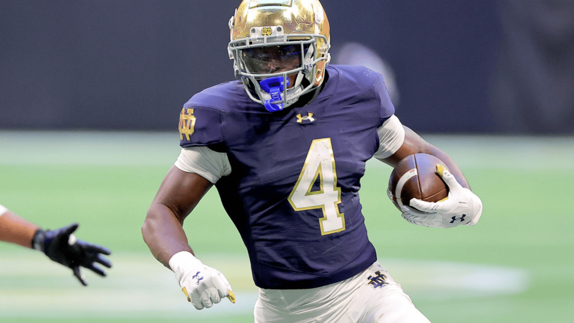 jeremiyah love in a blue and gold uniform runs with the ball during a game