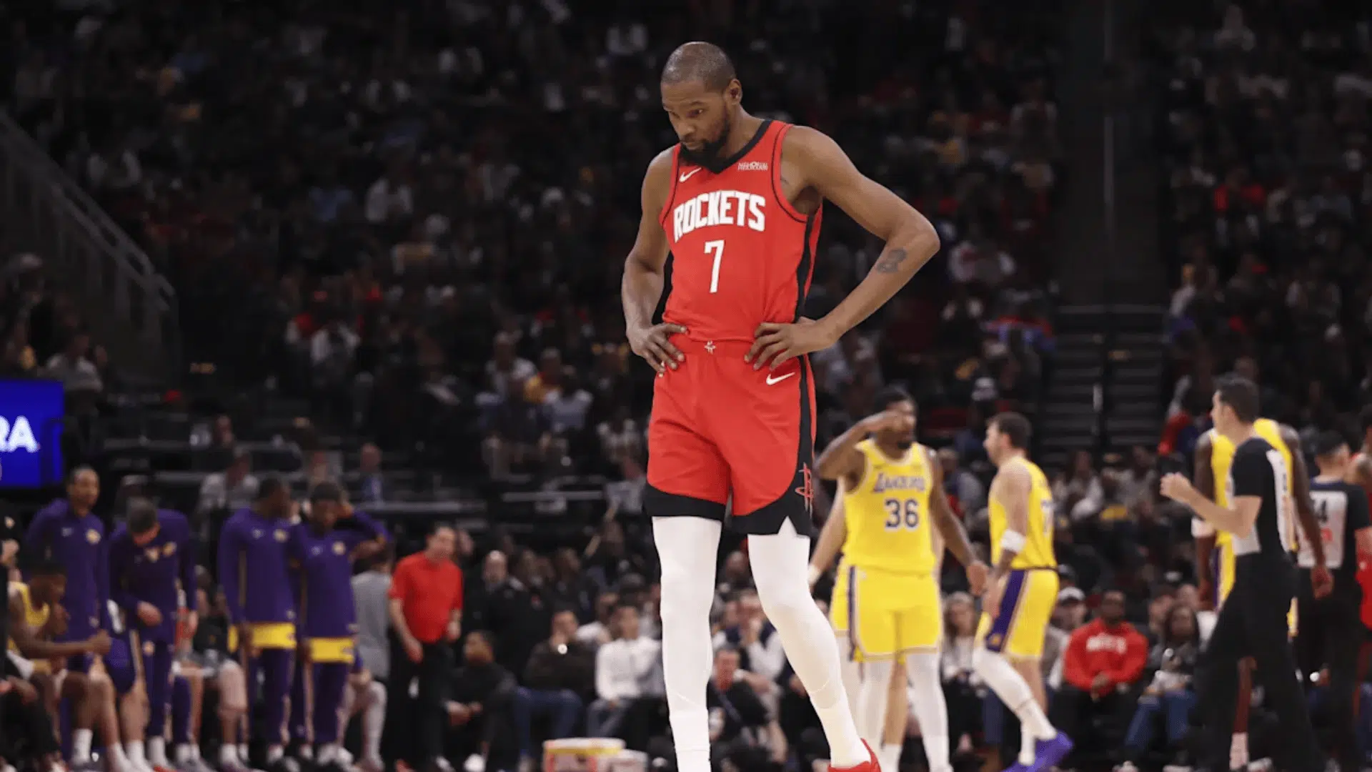 kevin durant in Houston jersey walking on court during nba game with players and crowd in background