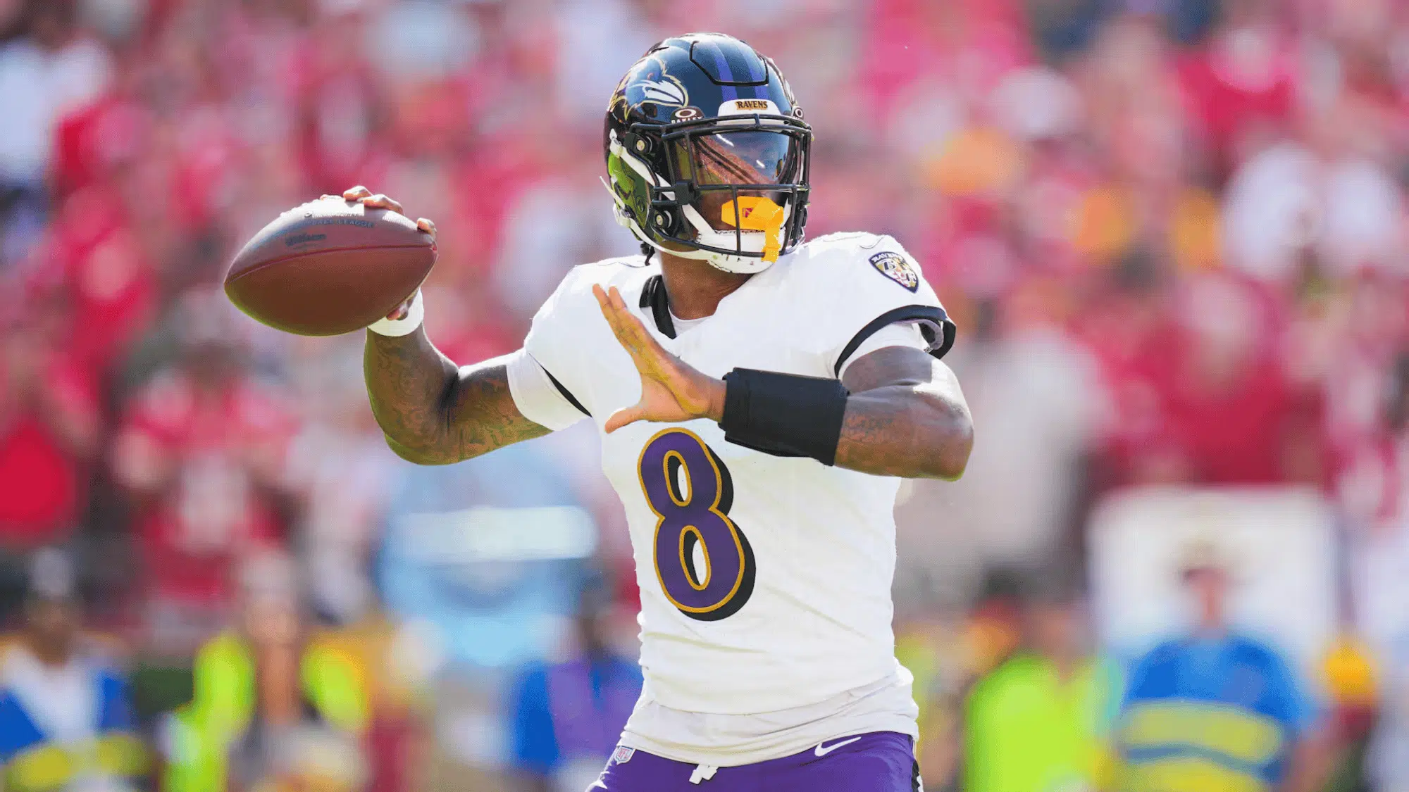 lamar jackson in a white jersey with the number 8 prepares to throw a pass