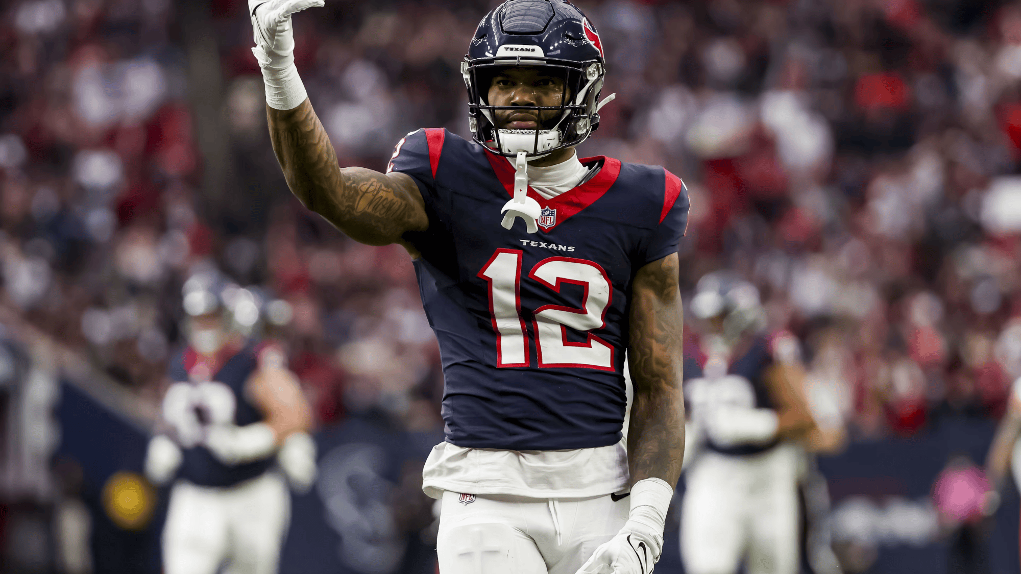 nico collins in a texans uniform, number 12 gestures on the field with a focused expression