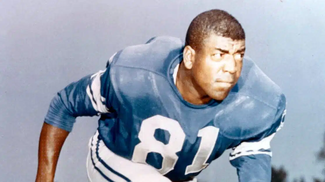 night train lane in a blue jersey with the number 81 crouches in a ready stance, focused expression