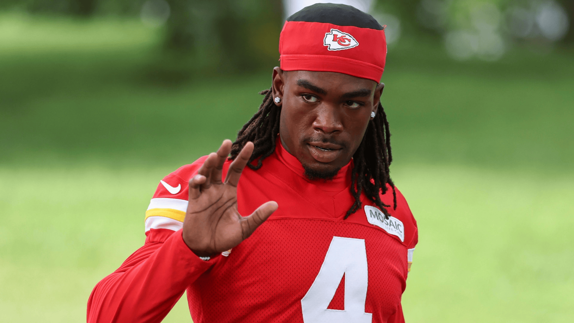 rashee rice in a red jersey with the number 4 and a red headband practicing on a field
