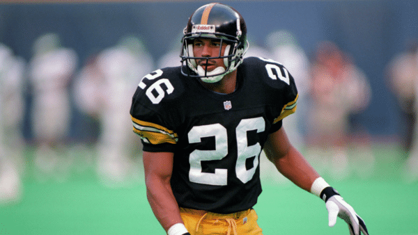 rod woodson wearing a black jersey with number 26 and a helmet stands ready on a field