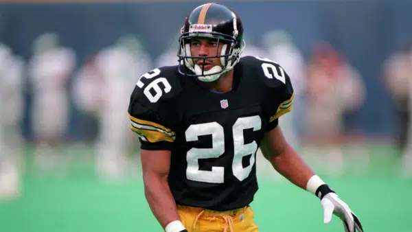 rod woodson wearing a black jersey with number 26 and a helmet stands ready on a field