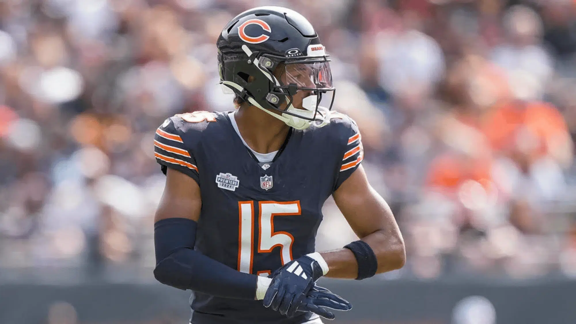 rome odunze in a navy chicago bears uniform and helmet on the field number 15 visible