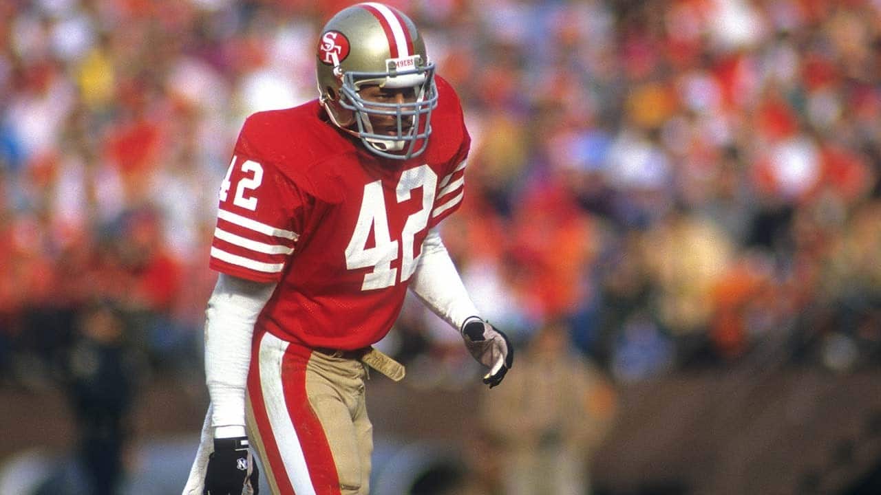 ronnie lott in red jersey number 42 stands focused on the field