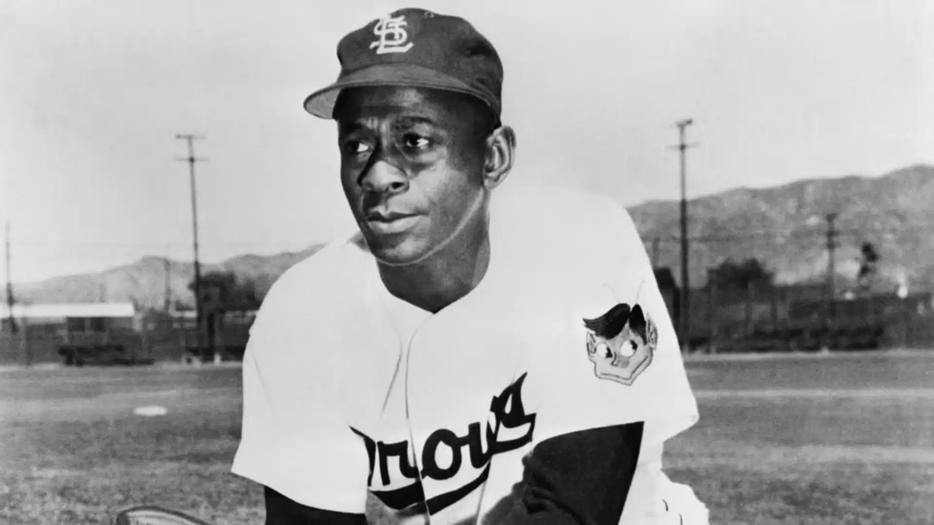 satchel paige among oldest active mlb players posing in classic baseball uniform on field during historic era of baseball career
