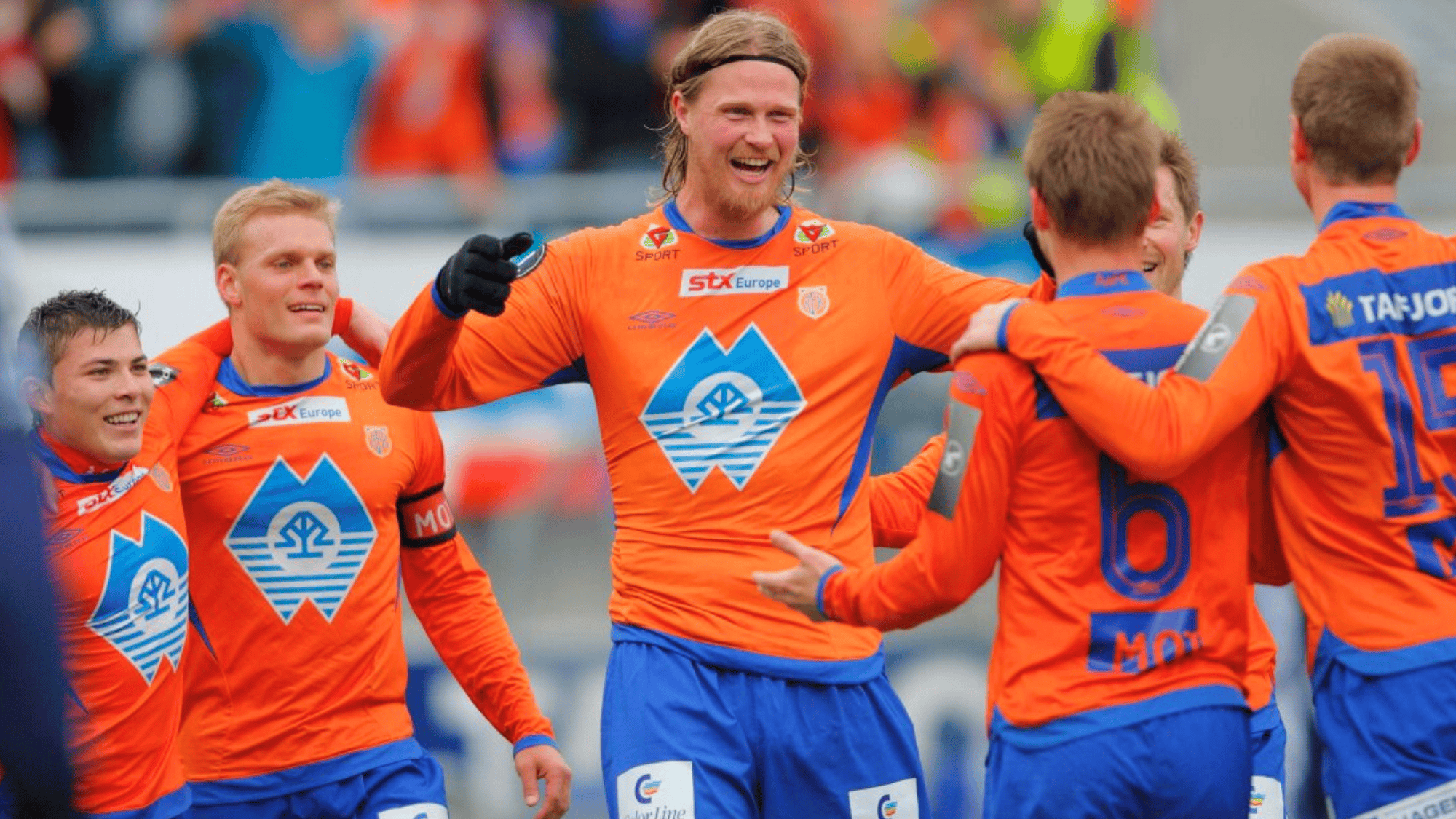 tor hogne aarøy is celebrating with teammates in an orange kit likely playing for a Norwegian team such as Tromsø IL