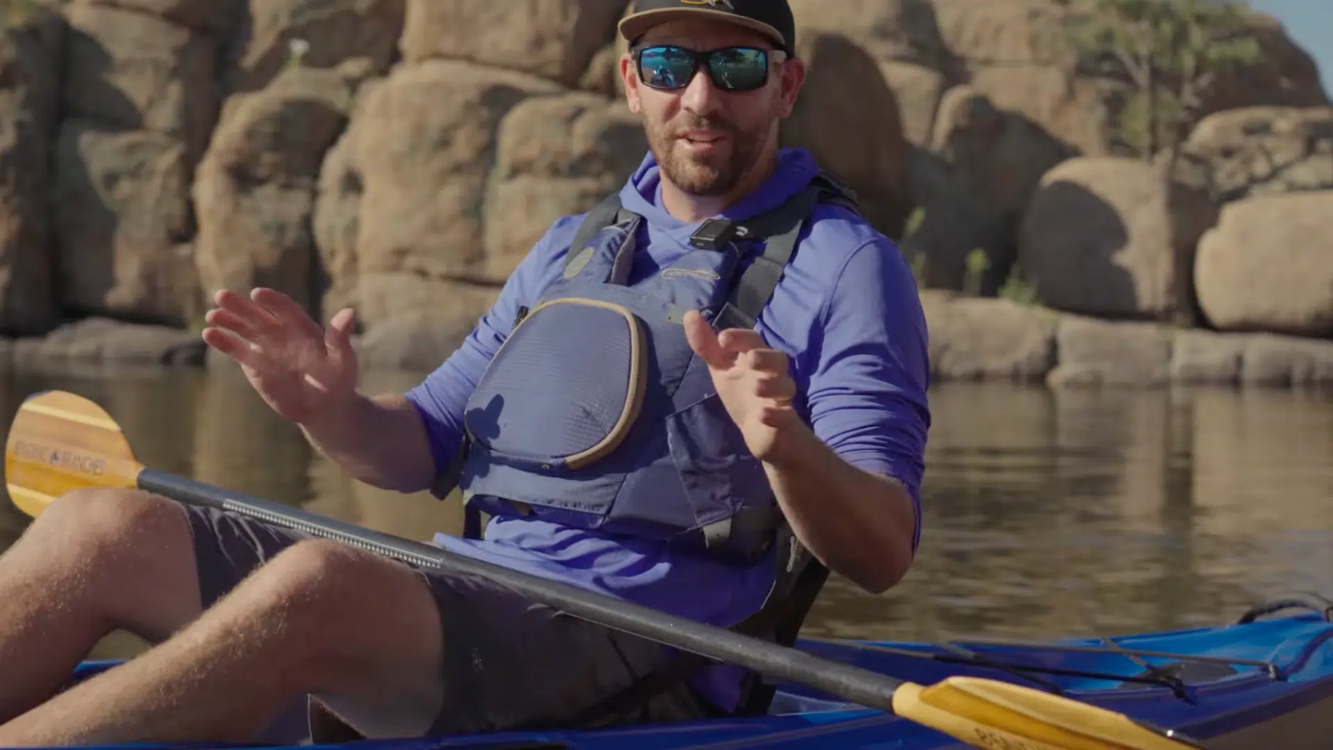 a person sits in a kayak adjusting footrests and seating position to maintain balance and comfort