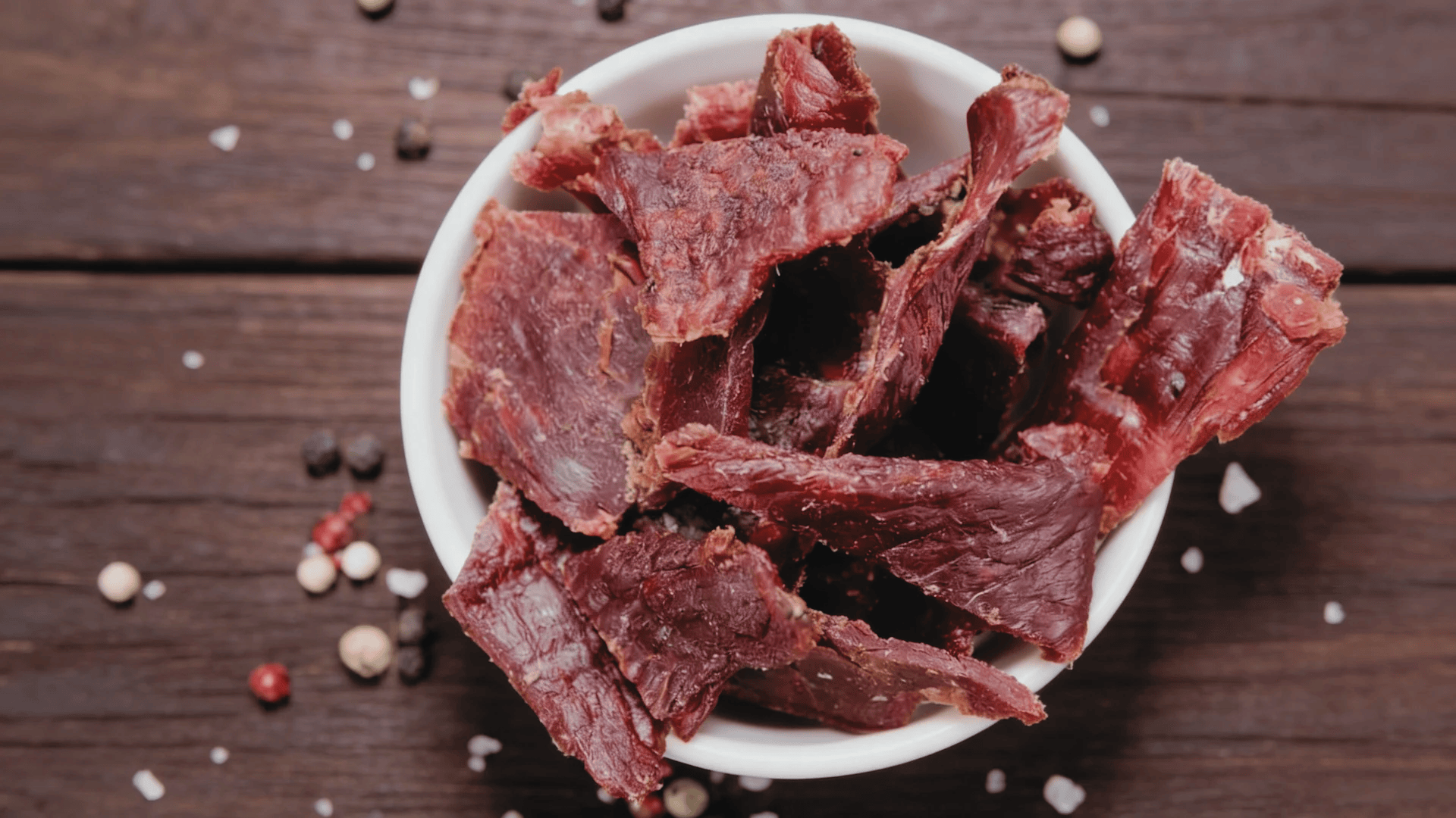 beef jerky pieces in a bowl on a wooden table