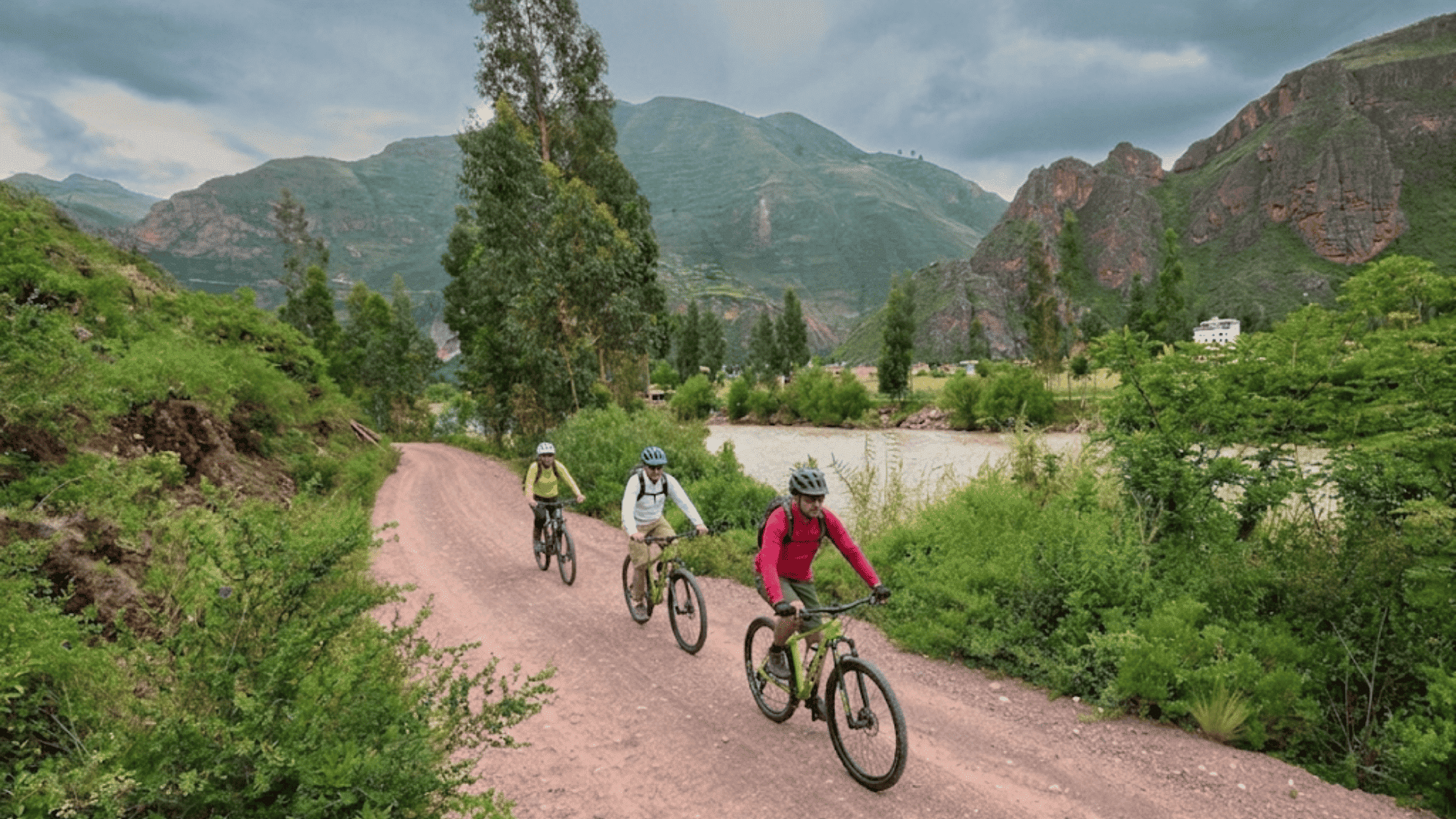 bikers riding on dirt trail near lake in tahoe rim trail with mountains trees and cloudy sky