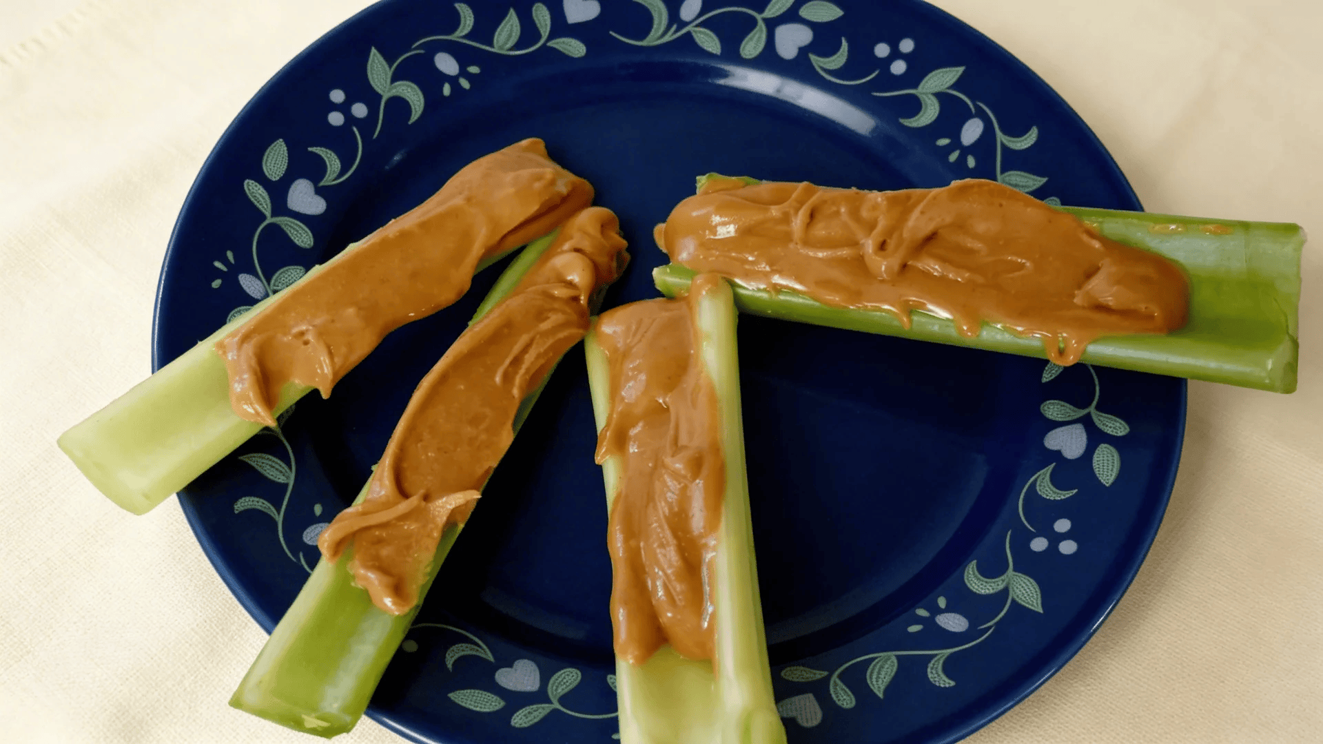 celery sticks with peanut butter on a blue plate