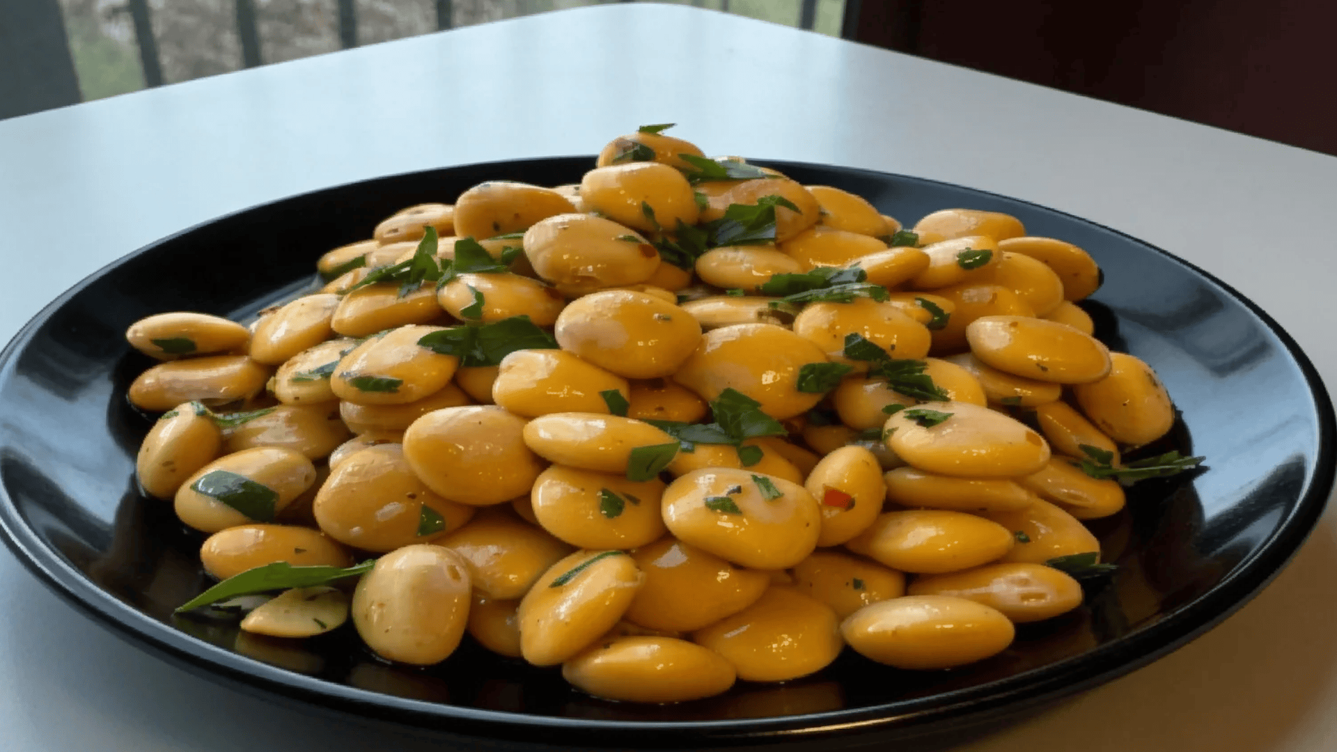 lupini beans with herbs on a black plate