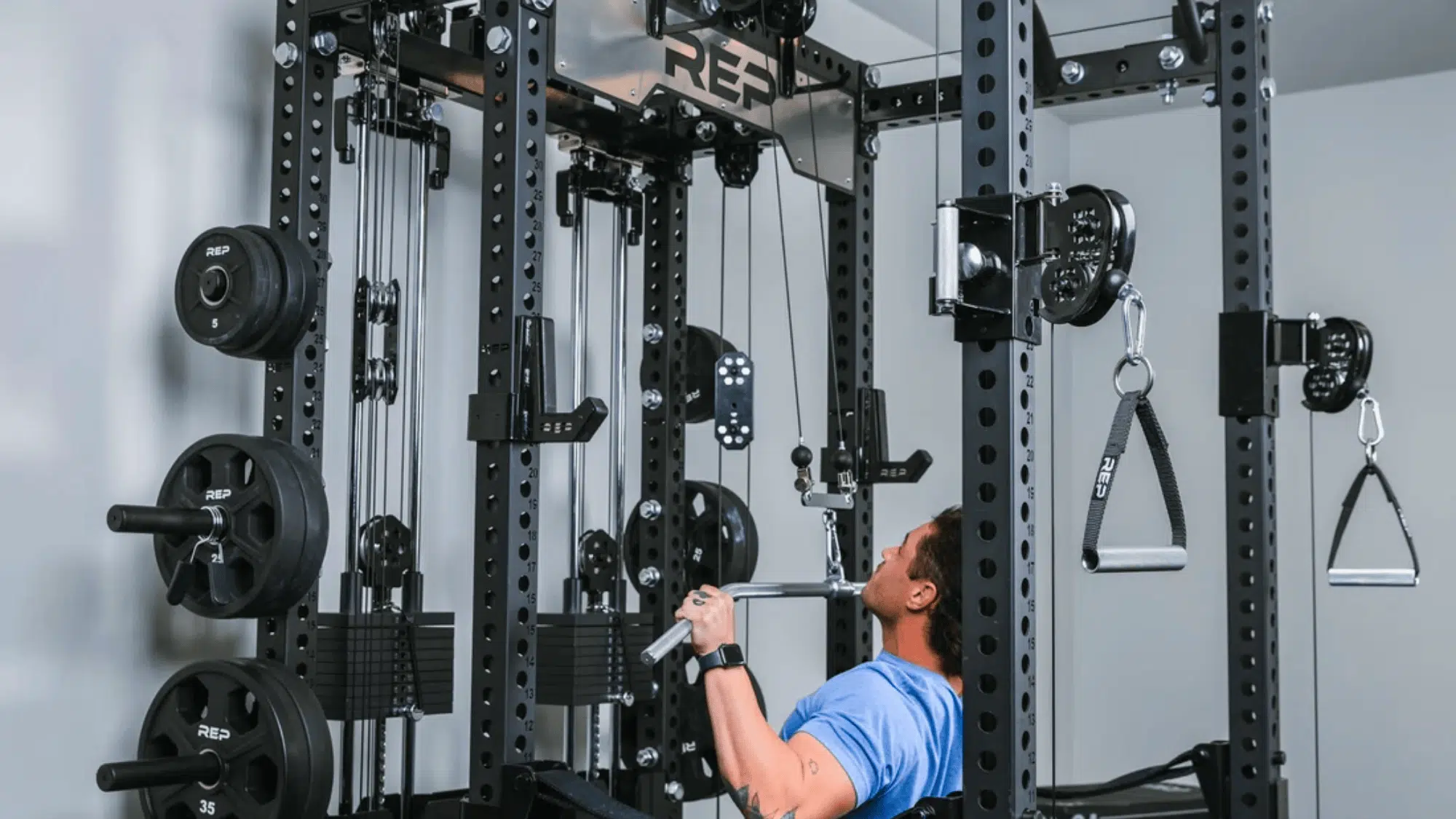 man using cable machine in gym performing lat pulldown exercise with weights and metal rack equipment
