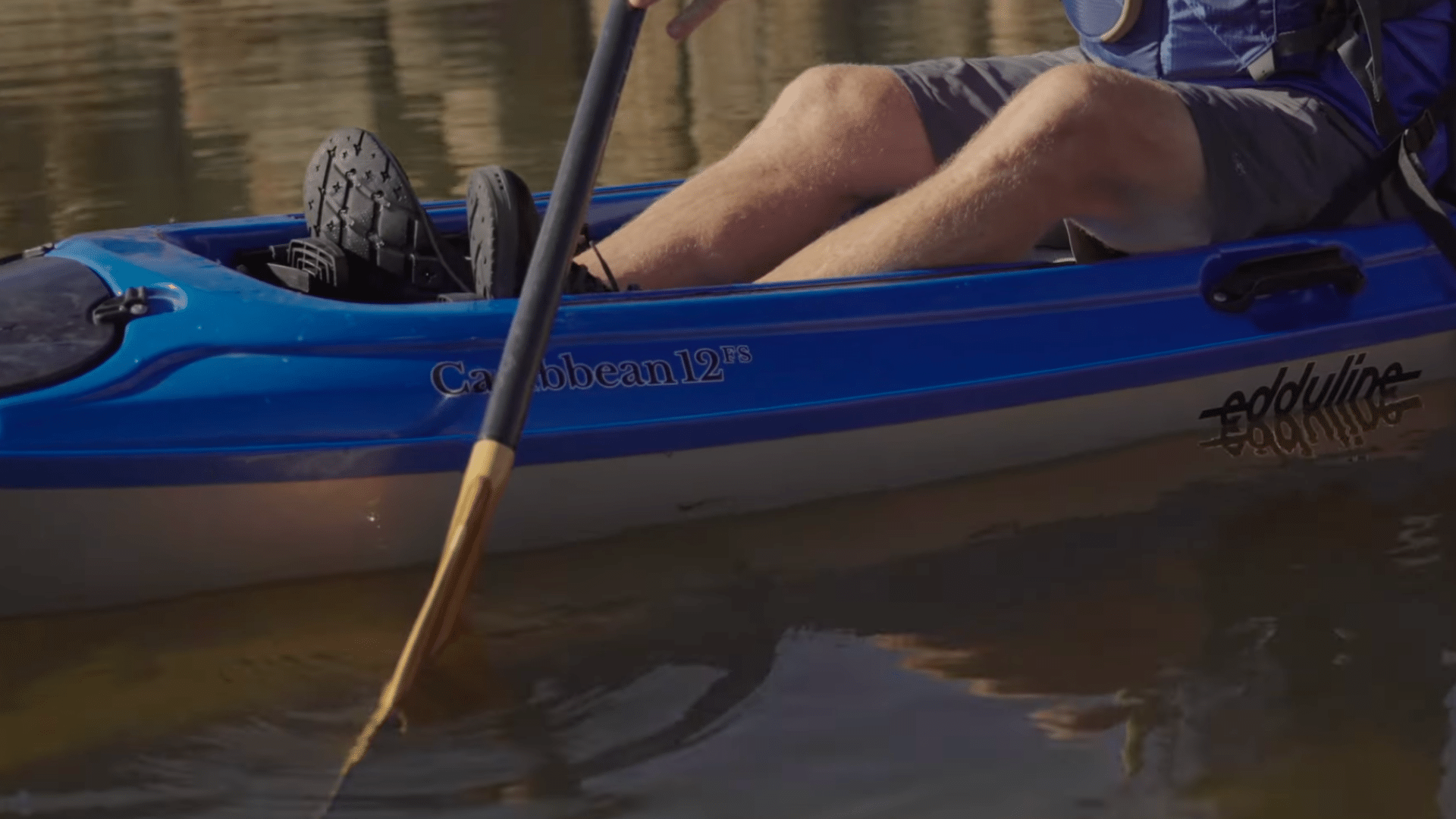 paddles a kayak forward using alternating strokes with proper technique maintaining balance