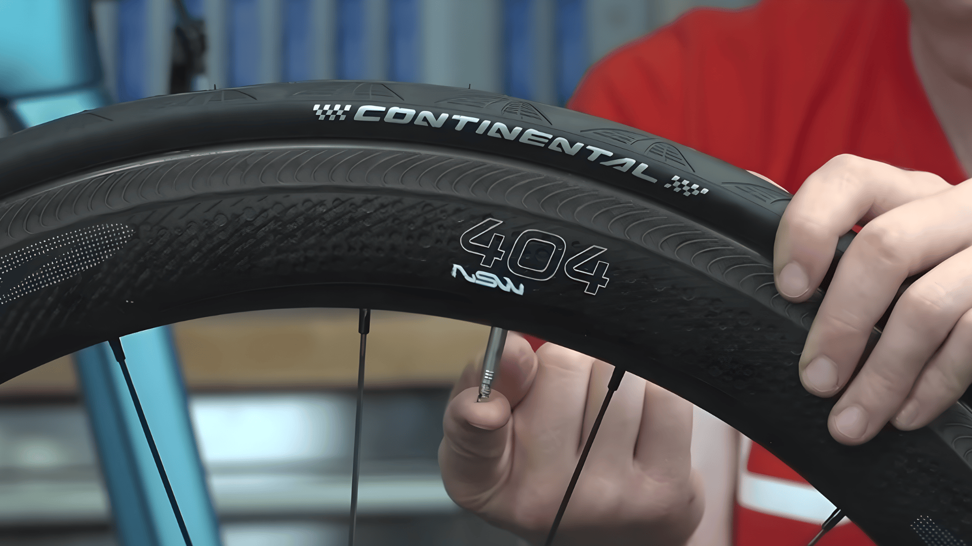 person holding a road bike wheel and valve demonstrating how to change bike tire with continental tire close view