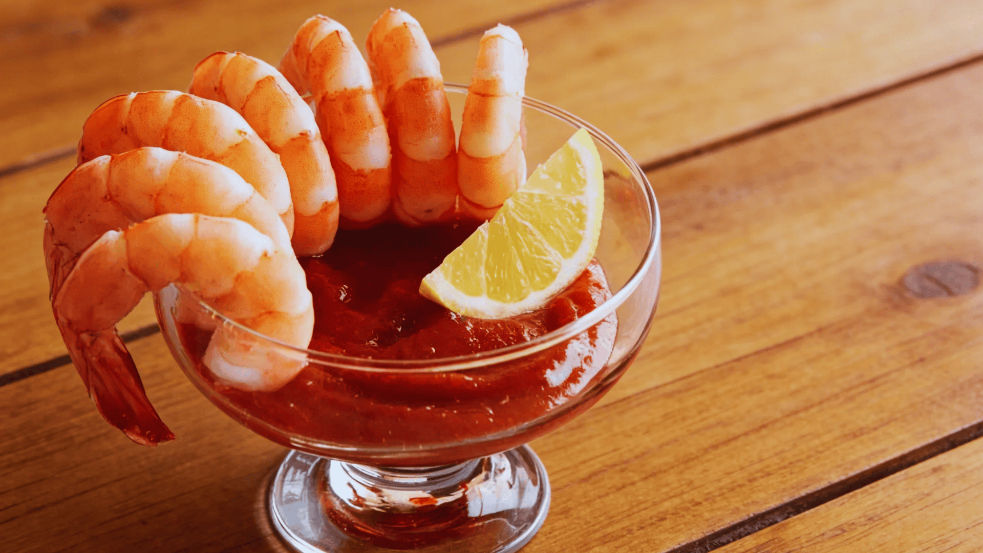 shrimp cocktail with sauce and lemon in a glass bowl