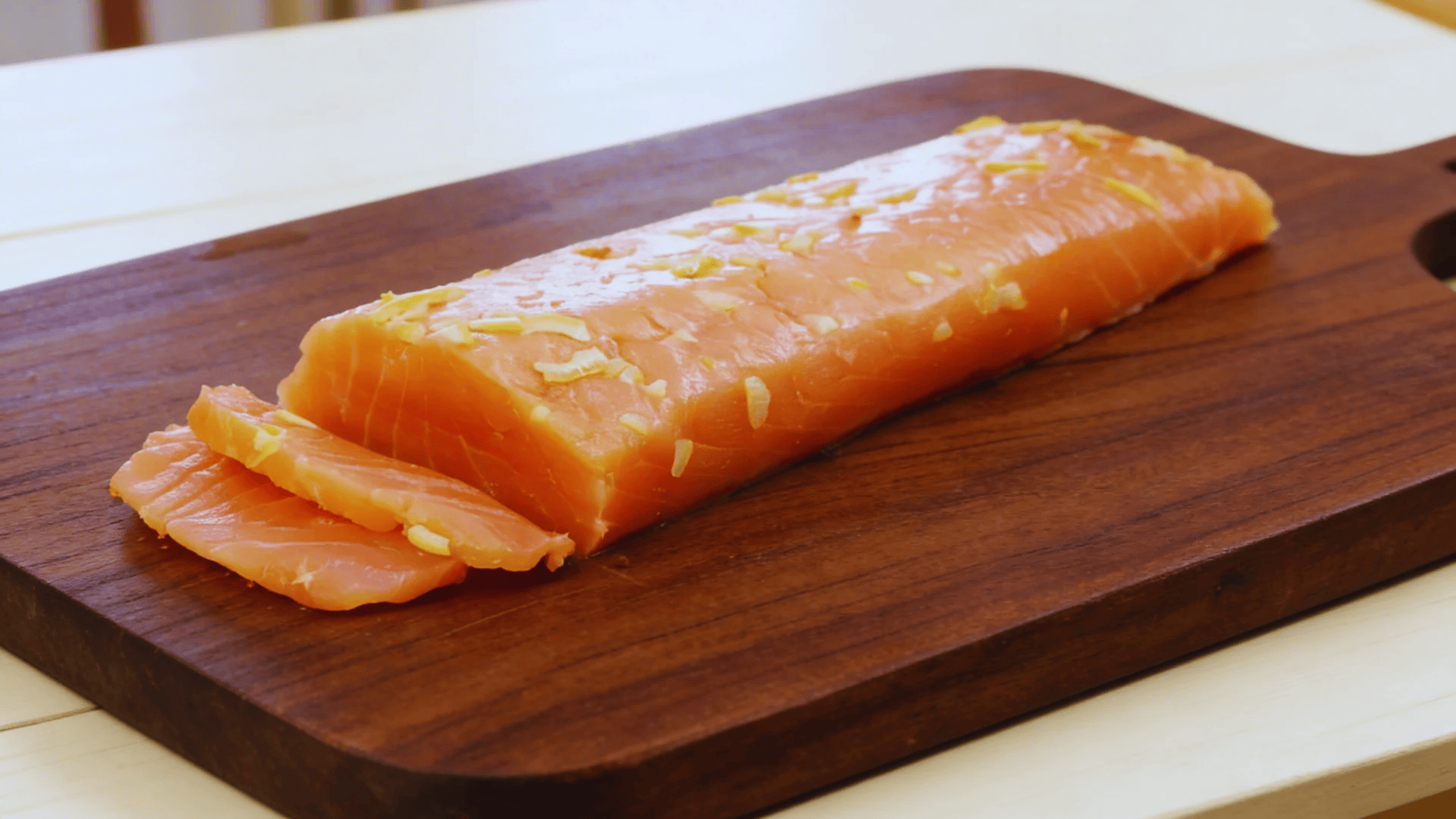 sliced salmon fillet on a wooden cutting board