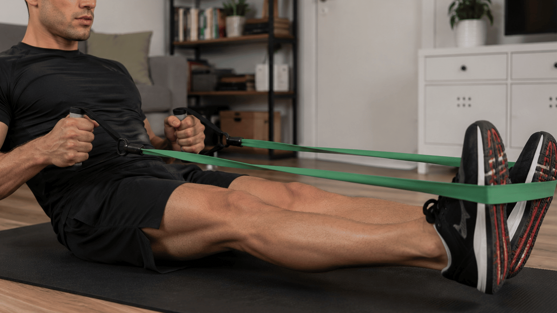 athlete using resistance bands for stretching and muscle recovery during a home workout session